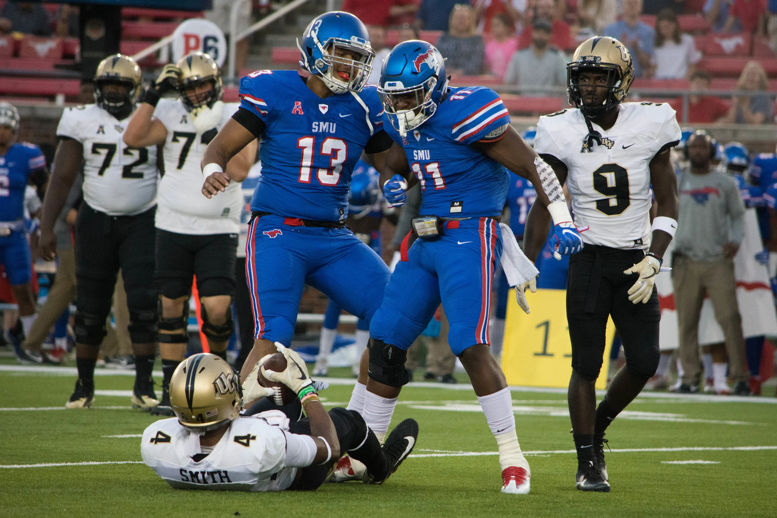 SMU's Tyson Neals and Kyran Mitchell celebrate after a huge hit on UCF's Tre'Quan Smith.