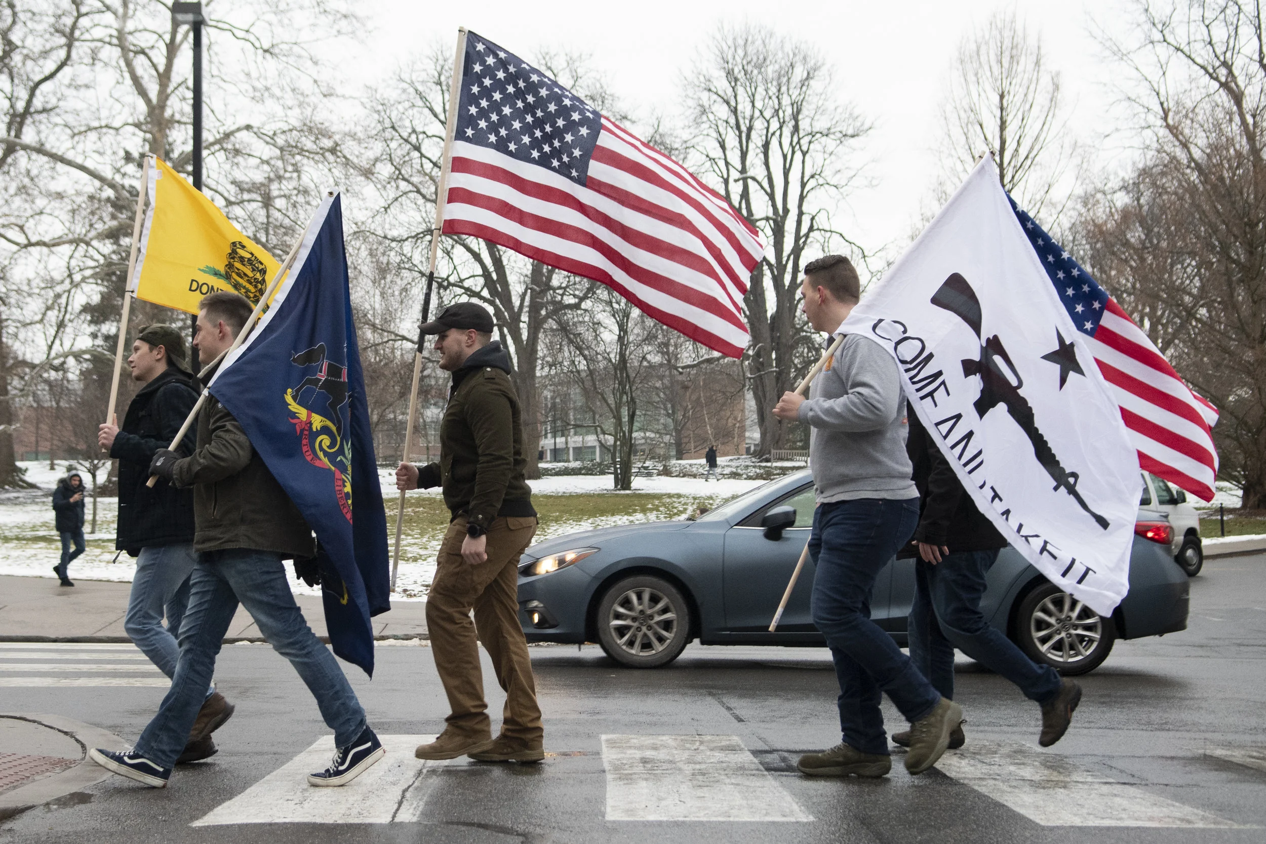 Protesters march down West College Ave. holding flags for the Come and Take It, Hogg protest at the Allen Street Gates on Friday, Jan. 18, 2019. - Photo by: Noah Riffe