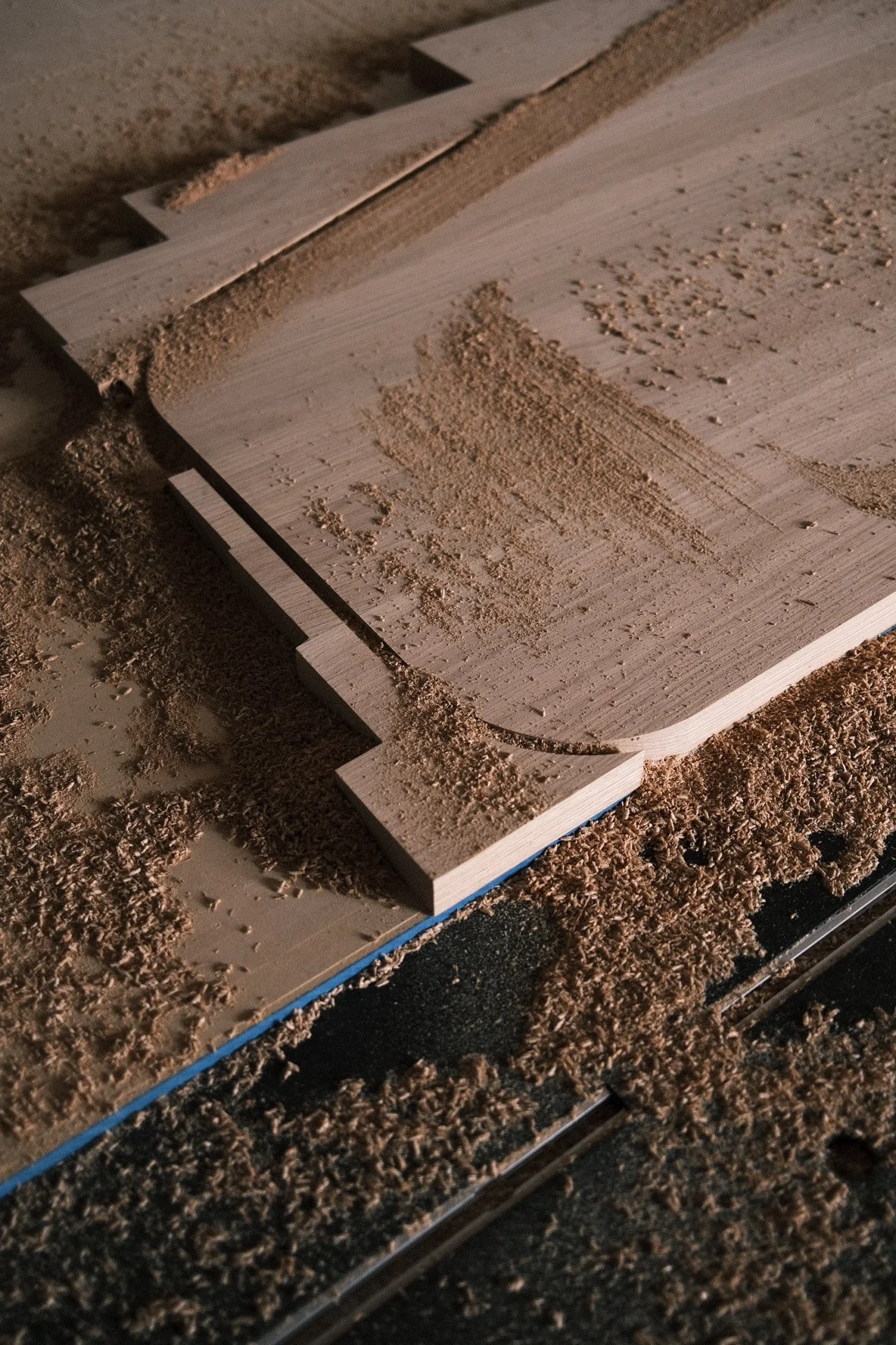 CNC-cut white oak parts in a bed of sawdust, Little While café millwork fabrication