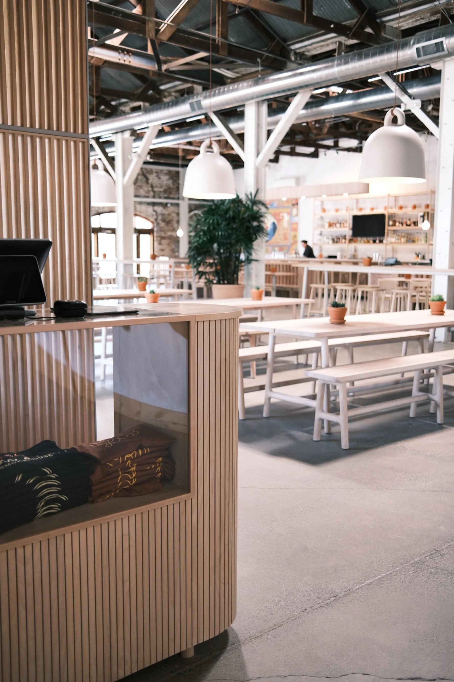 White oak slat-clad host stand with communal dining tables at Slow and Low, Elk Grove