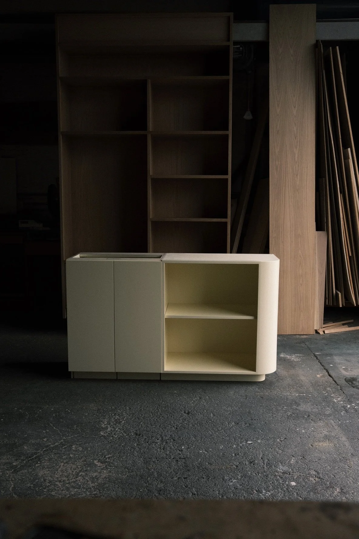 Curved-end cabinet with open shelving before finishing, Little While casework