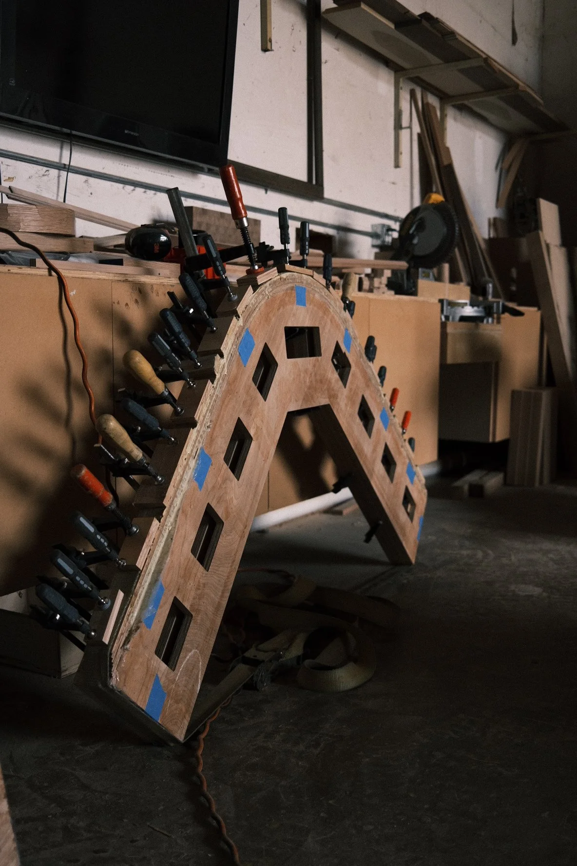 Glue-up of a curved arched frame held with spring clamps in the PhillBuilt shop