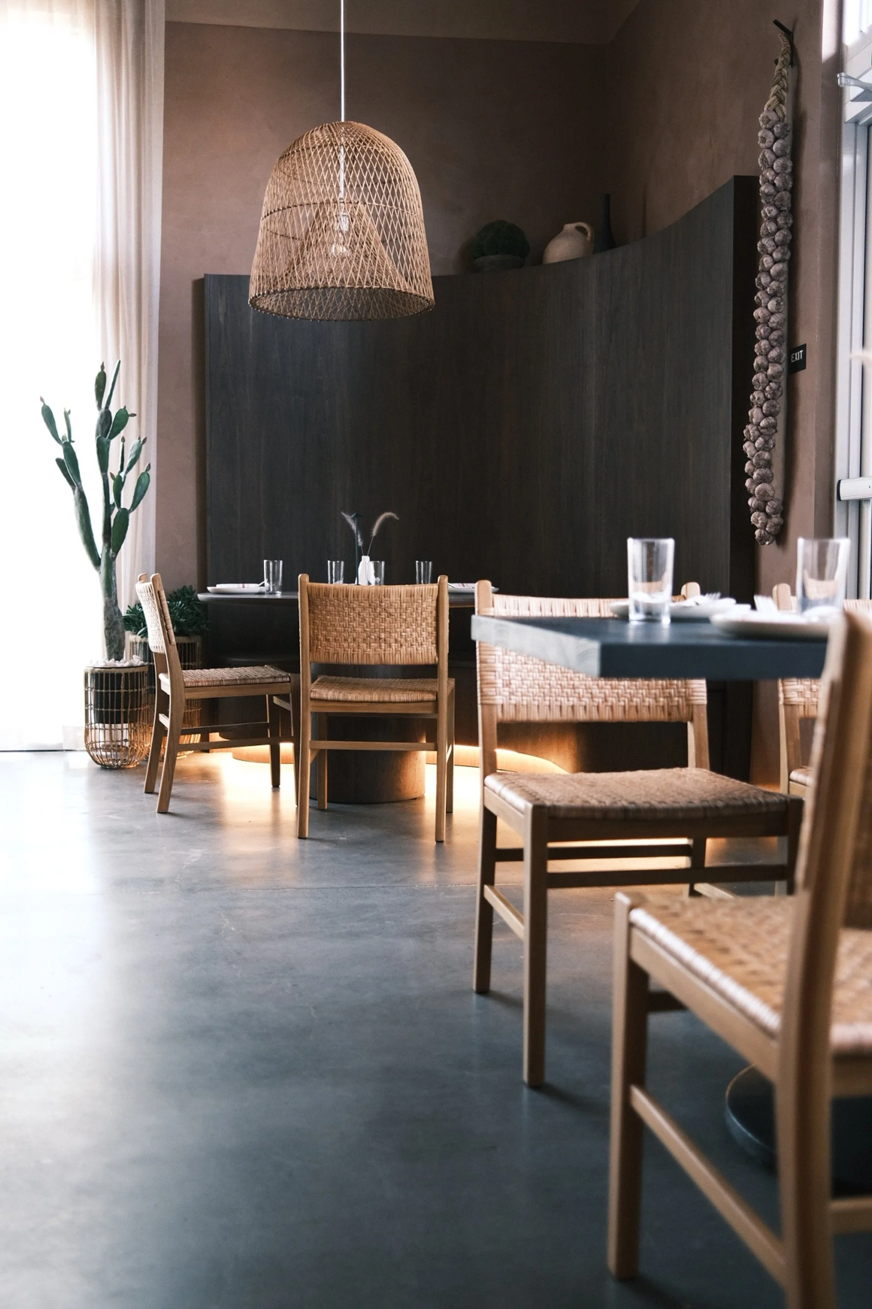 Ebonized dining tables and rush-seat chairs with LED-lit banquette base at Cantina Pedrigal, Folsom