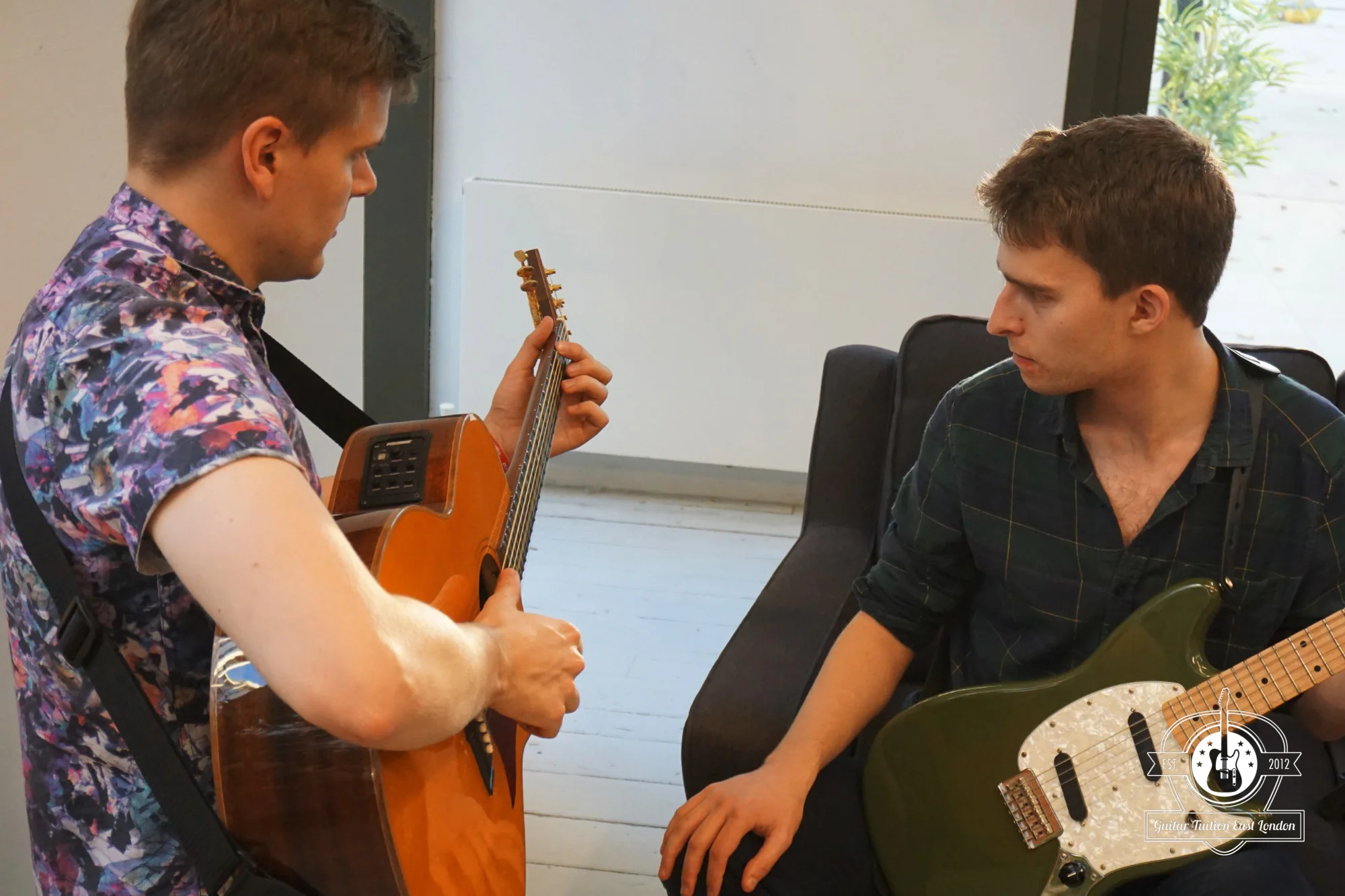 One of our teachers, Darryl with Rob, our student working on fingerpicking.