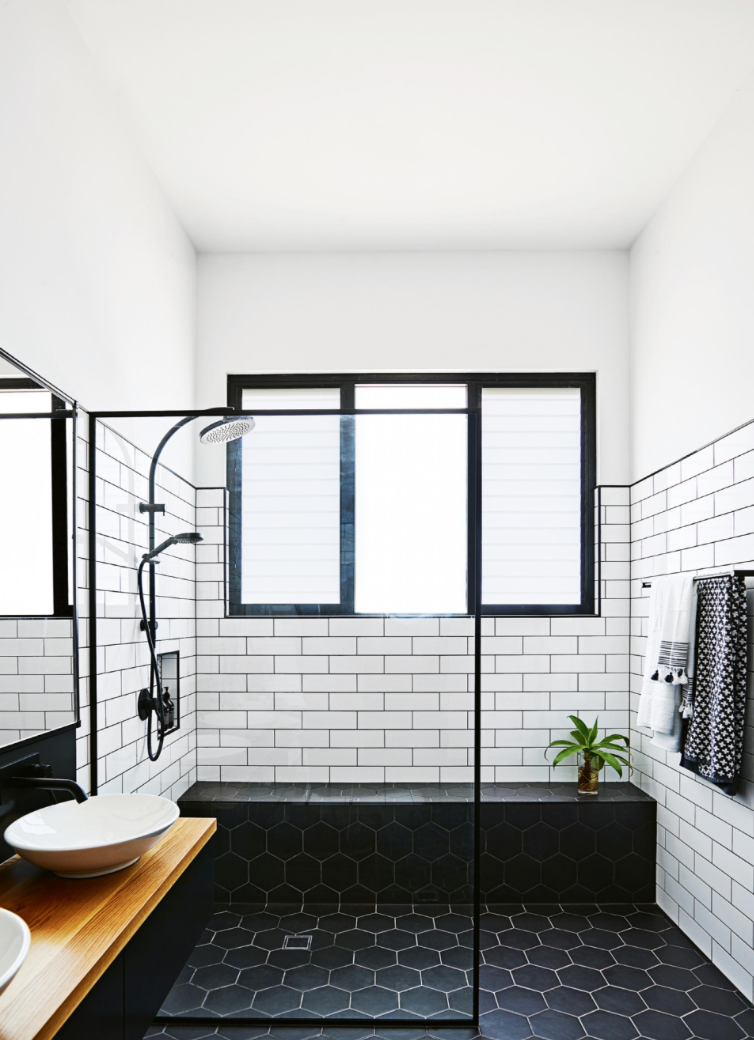 2. Tile Try tiling your bathroom floor in black, like here with a 8" hexagon shape. We love how they used white grout to give it another layer, and created a smooth transition between the shower and rest of the bathroom floor. This seamless look makes the floor the focal point of the room. Bringing in a wood countertop and plant softens the look.