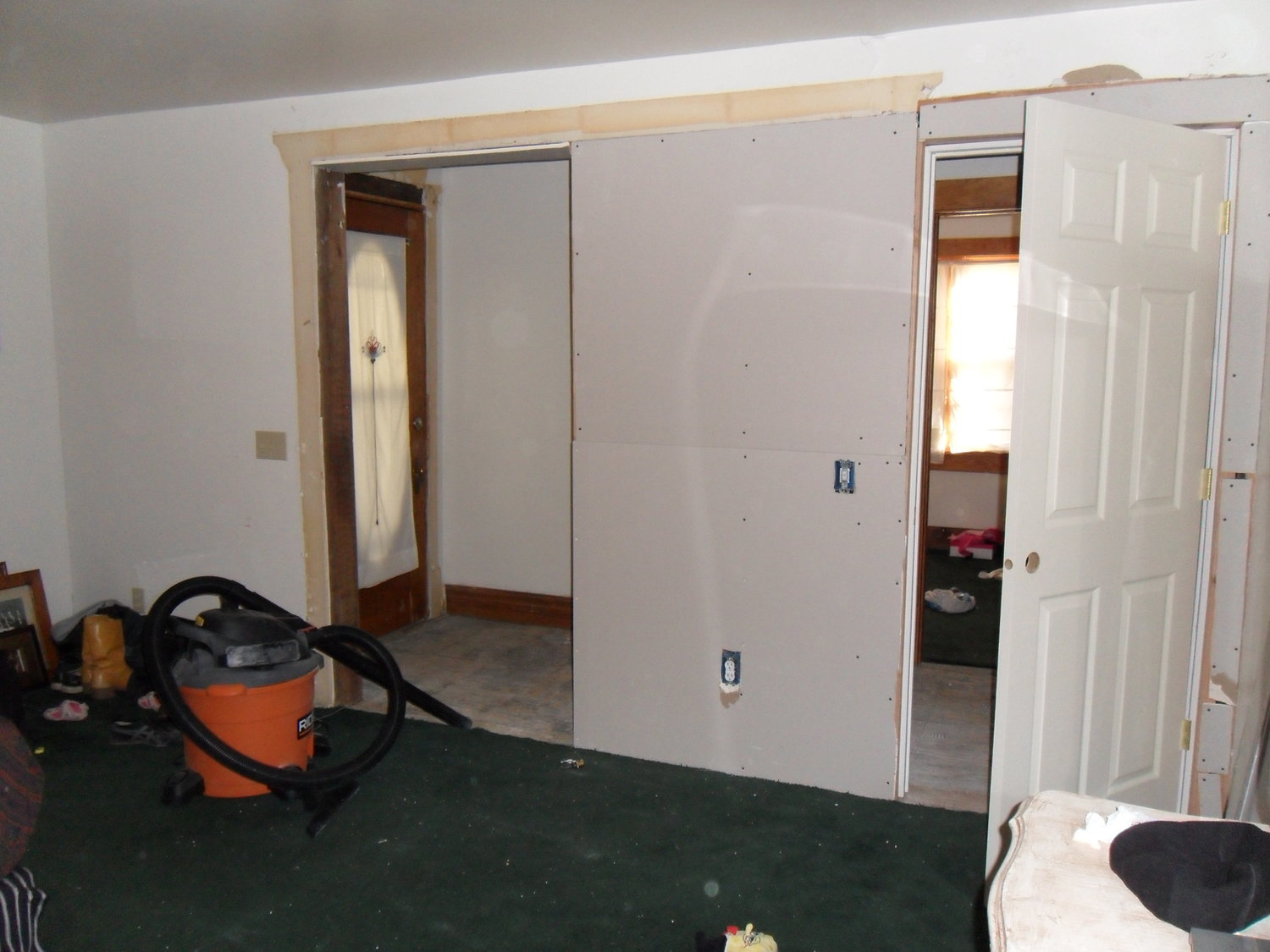 Archway framed in for a closet and new bedroom door. Notice the front door is still in place.