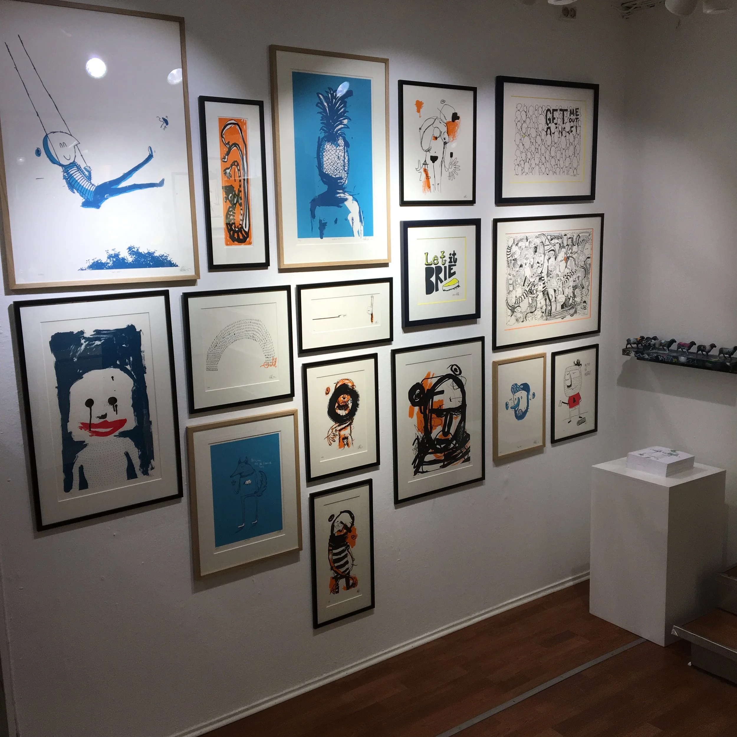 Silketrykkveggen med skulptur og bøker.