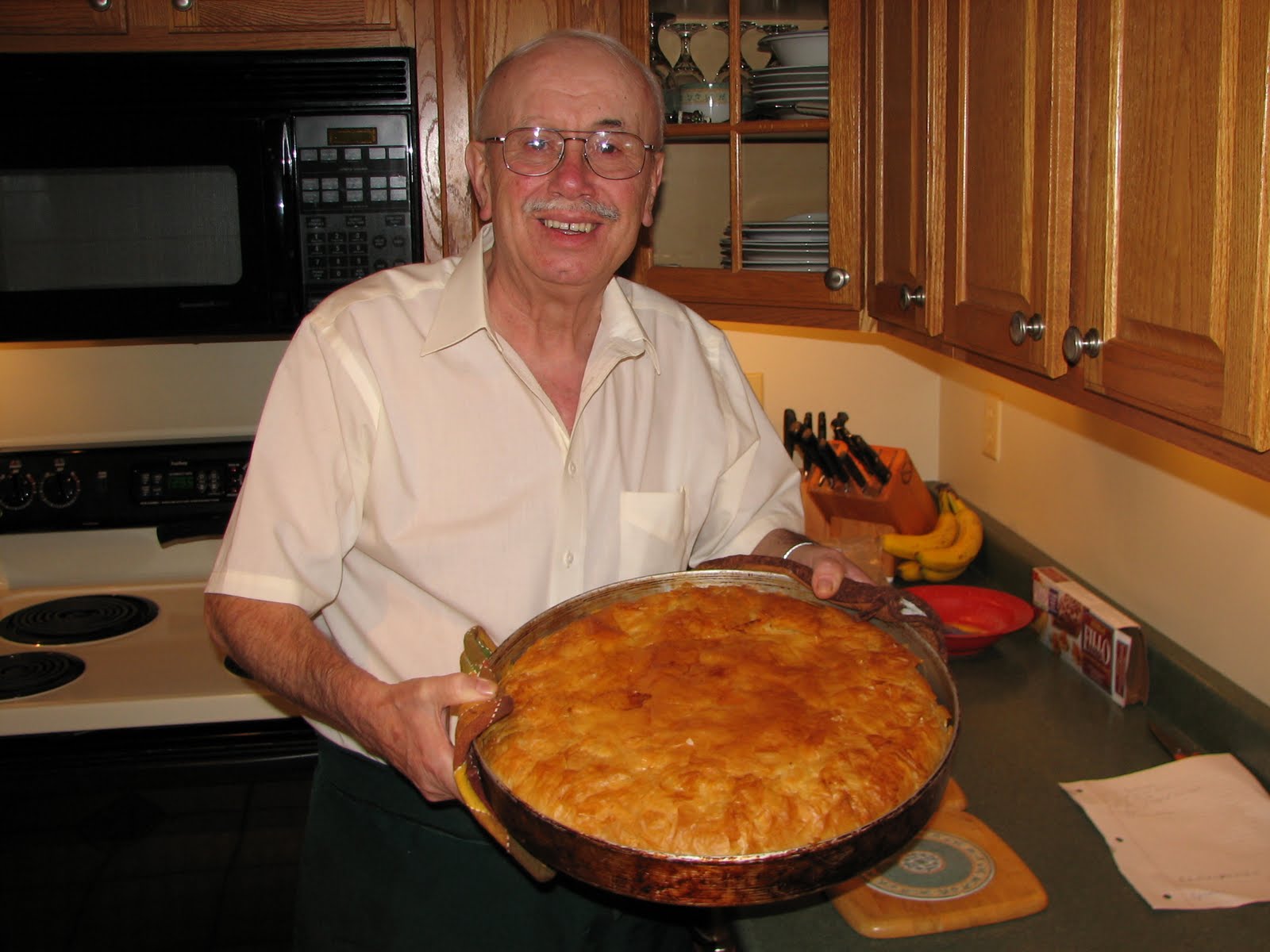   Bill Dilios, of Politsani, Albania, (formerly part of Greece) with his favorite food, a chicken and rice pie in phyllo dough.  