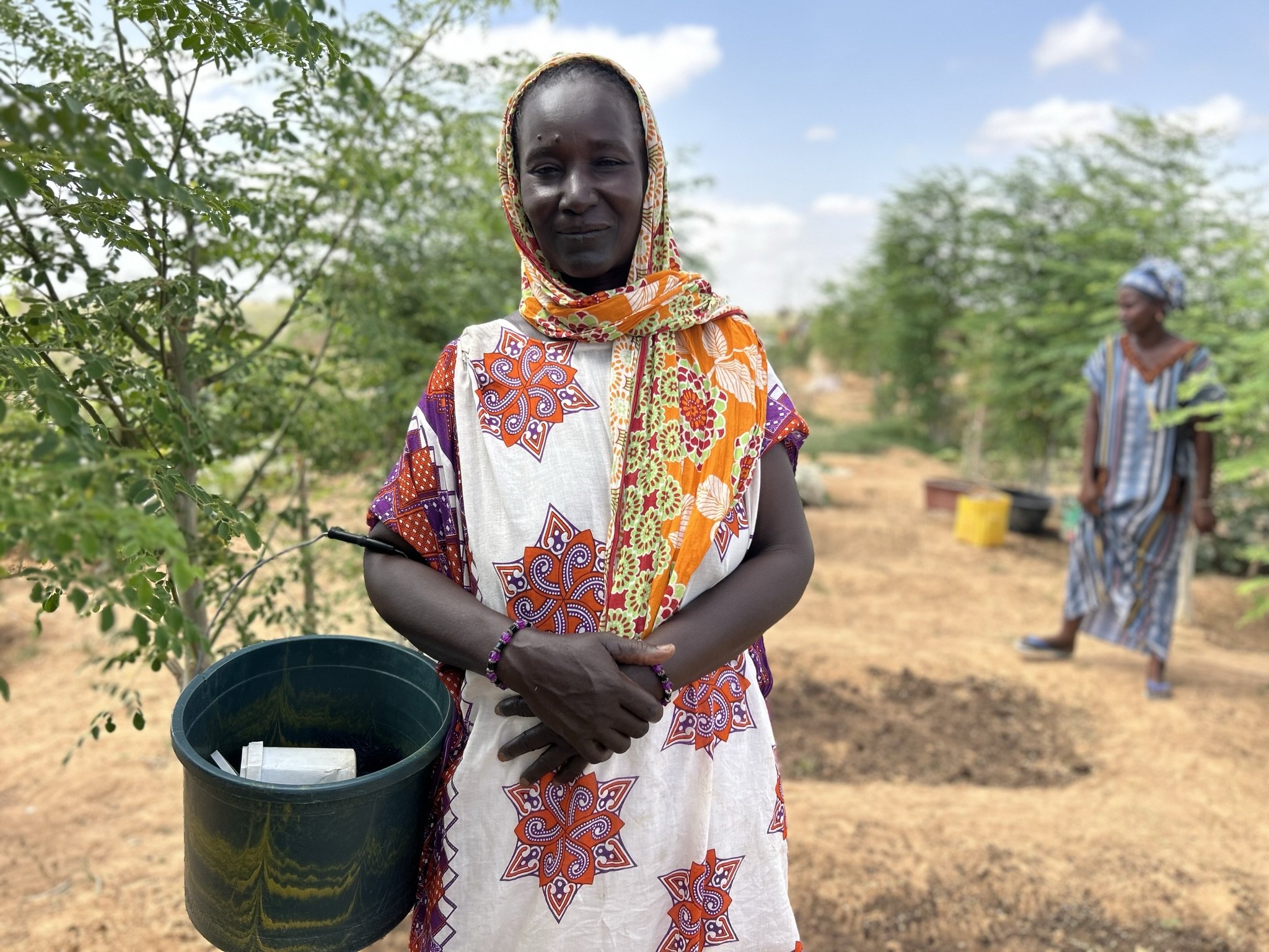 03_A woman from Togane stands proudly with her Moringa trees.JPEG