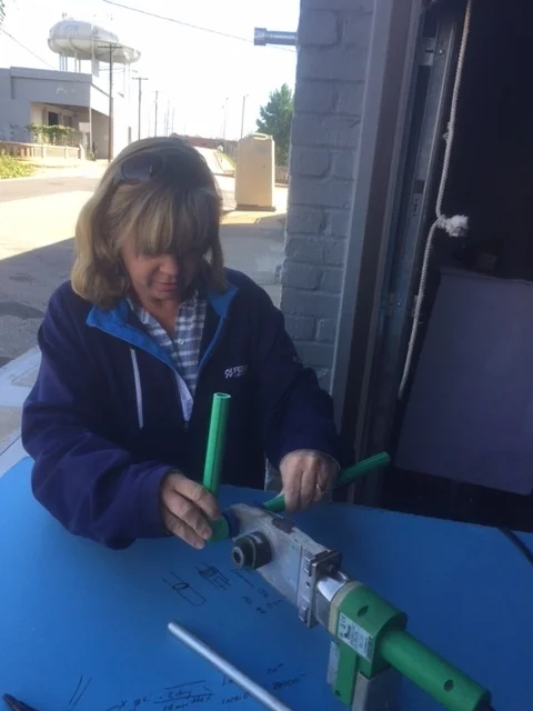 trish heating two ends of aquatherm pipe fittings before fusing them together.