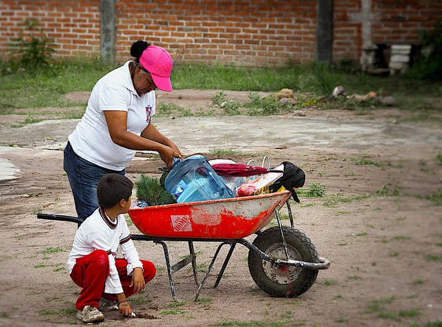Residente de Pozo Hondo lleva agua a casa de la cisterna comunitaria.