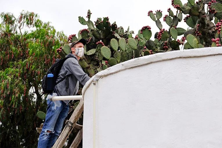 Foto: Matthieu de Caminos de Agua inspeccionando un Sistema de Recolección de Agua de Lluvia.