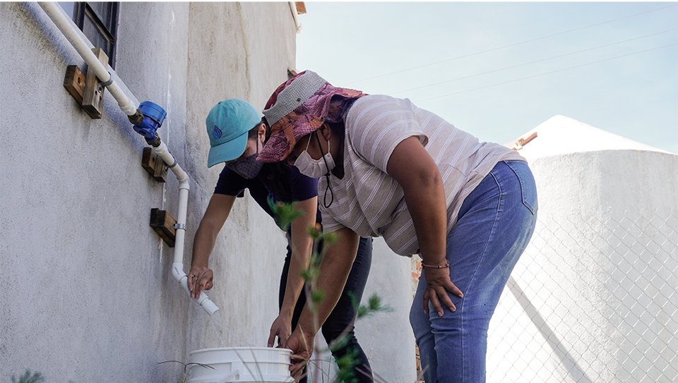 Photo: Allie Reiling, Caminos de Agua’s Director of Technology, together with a community leader opening the outlet of the Ground Water Treatment System "Pilot 2" in the community of Los Ricos.