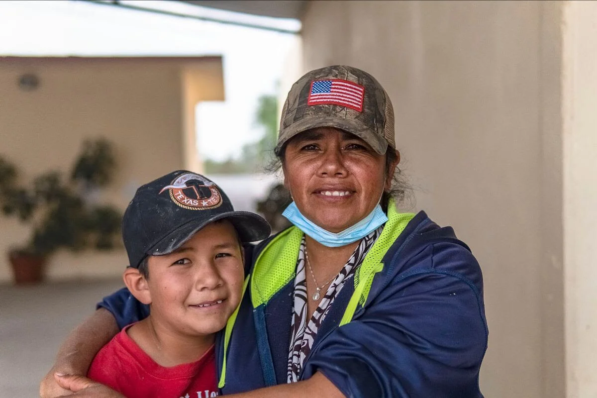 Foto: Madre e hijo sonríendo después de la construcción de un sistema de cosecha de agua de lluvia.