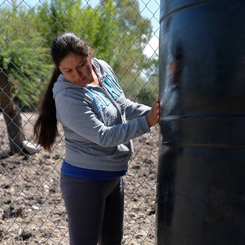 Foto: Rosario, miembro de la comundiad de Salitrillo haciendo una revisión de rutina del sistema de cosecha de agua de lluvia en la escuela pública de la comunidad.