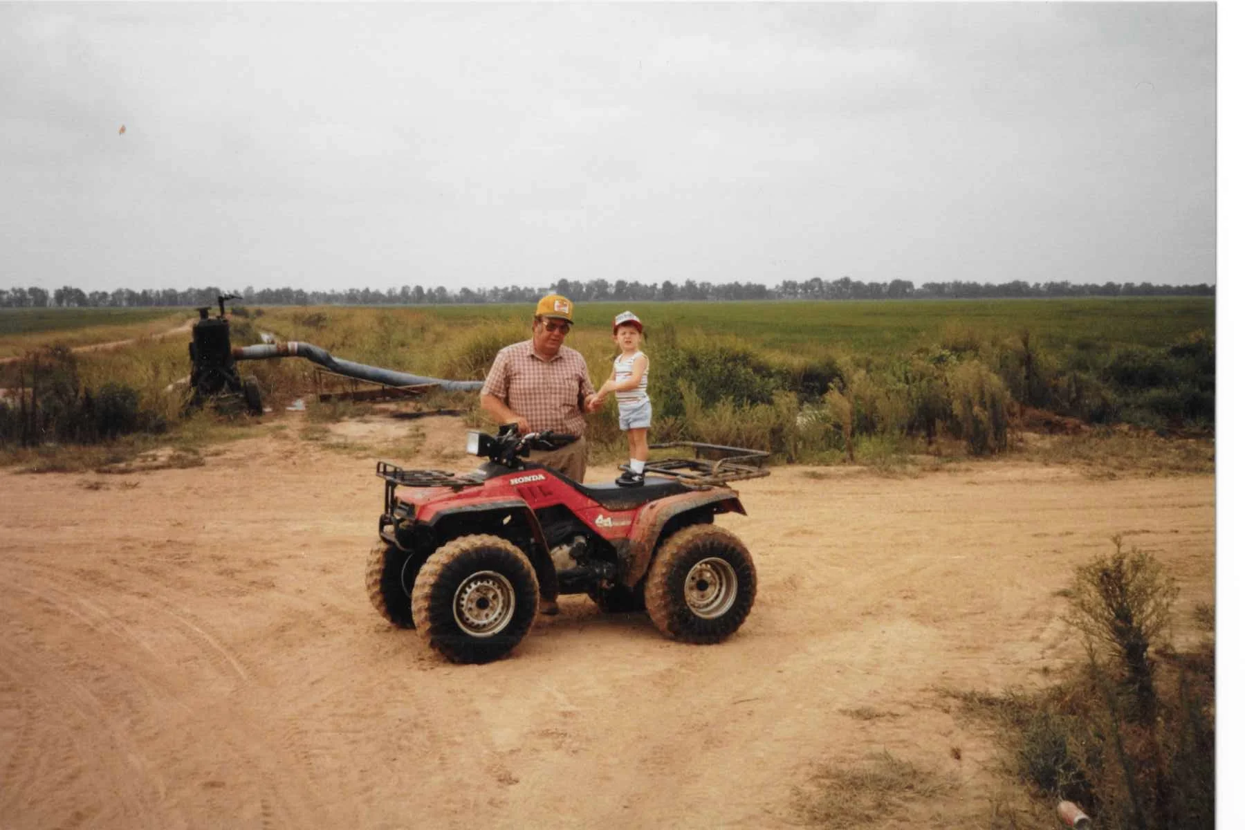 My dad and nephew in front of a well that supplies the water to surrounding rice fields