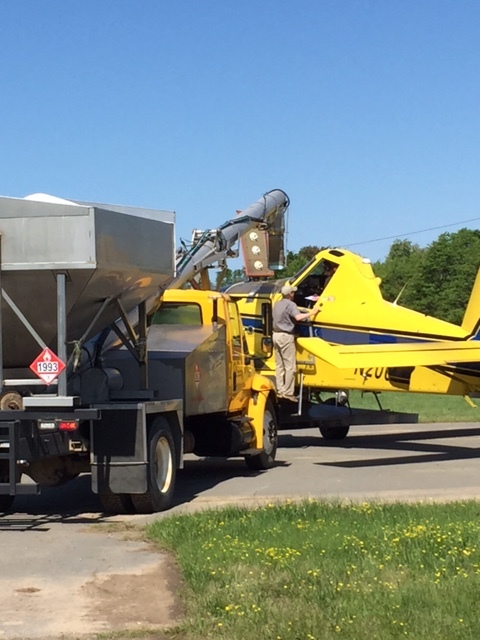 a carefully measured application being loaded into an ag plane
