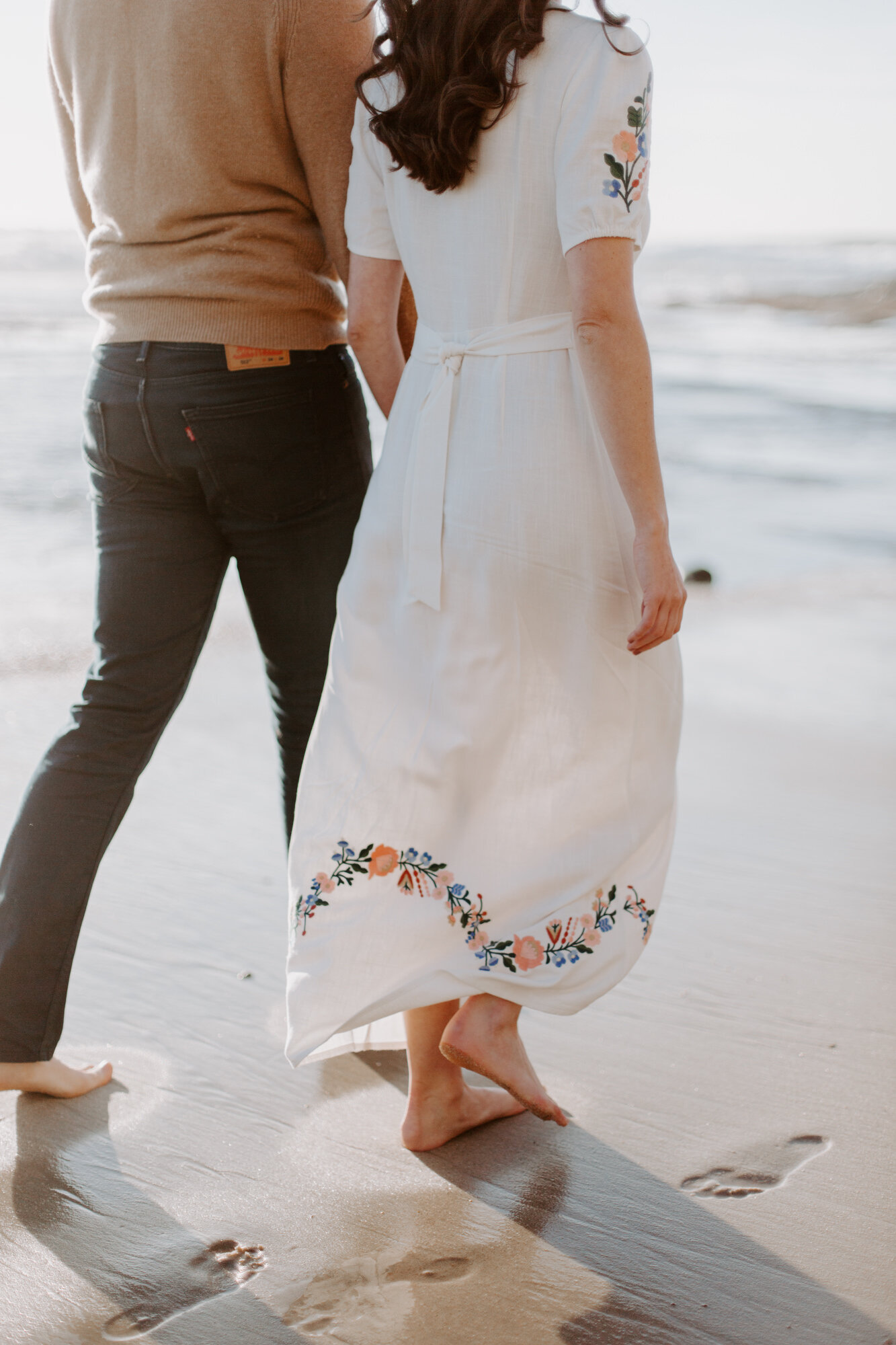 La Jolla Engagement Photos in San Diego with beach cliff and tide pools and on the sand.  Wore a white floral dress and took their engagement photos for their wedding by Kara Reynolds photography