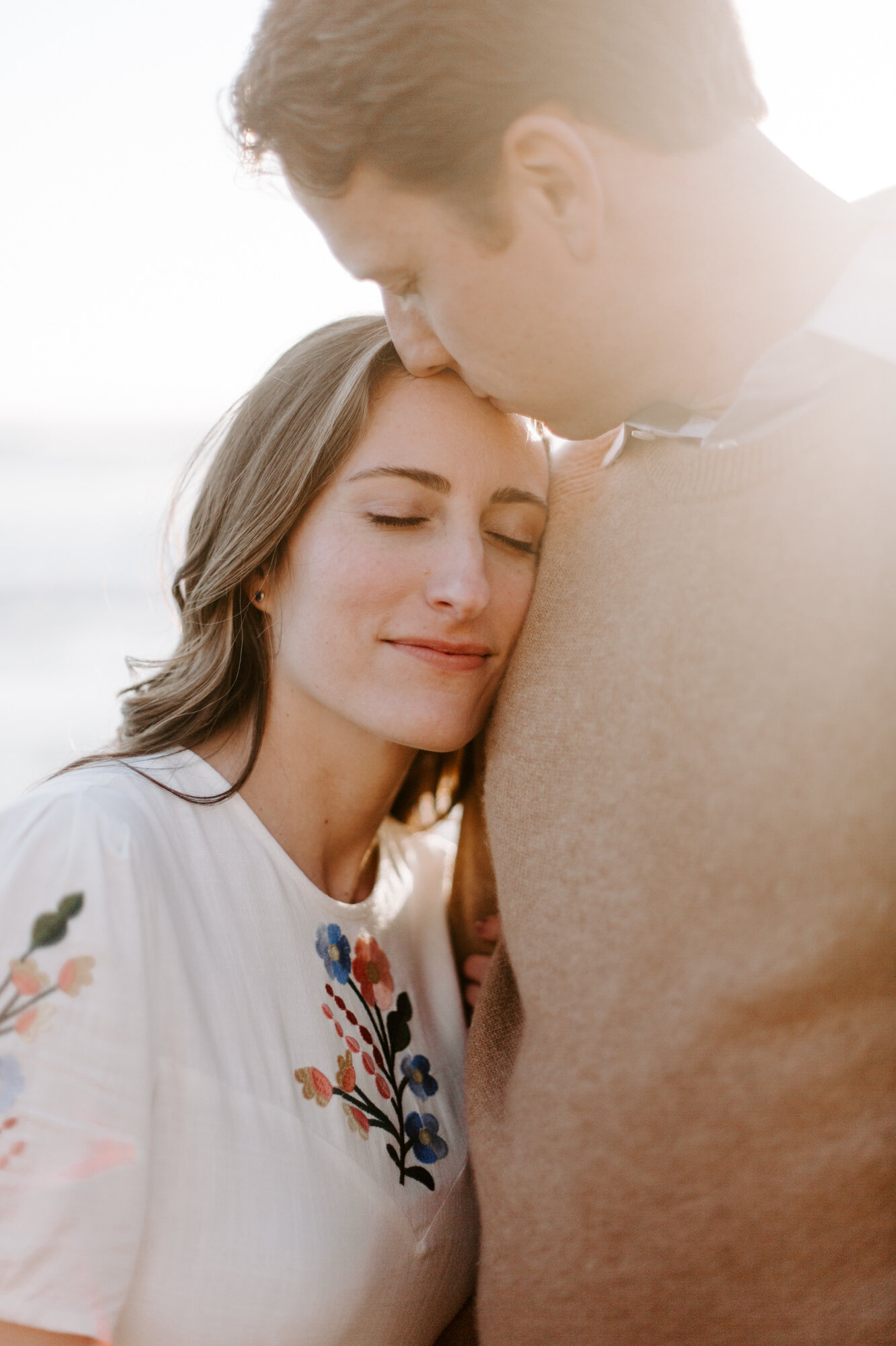 La Jolla Engagement Photos in San Diego with beach cliff and tide pools and on the sand.  Wore a white floral dress and took their engagement photos for their wedding by Kara Reynolds photography