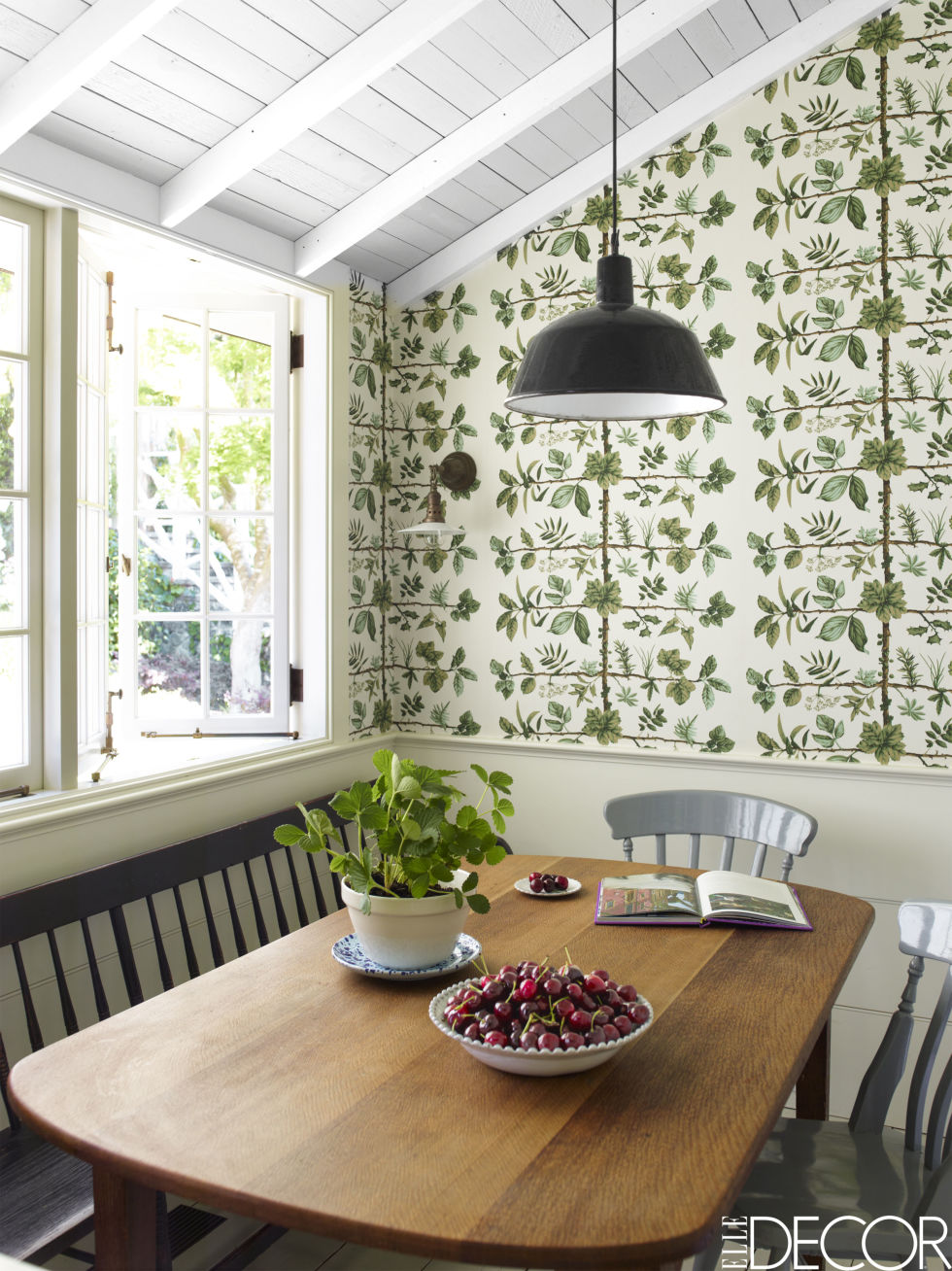 Traditional elements like the farmhouse chairs and botanical wallpaper from iconic French home furnishings company Pierre Frey keep the breakfast nook homely. High-gloss paint and an industrial light pendent keep it looking youthful. 