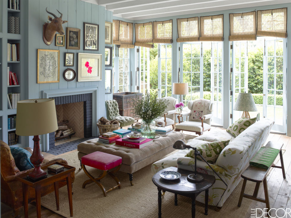 A traditional sofa was reupholstered in floral Raoul textiles and along is one of many neutral-coloured seating options in the family room. A fuchsia stool and punchy throw pillows prevent the look from being too dull. As a result, the overall feeling is colourful and vibrant.
