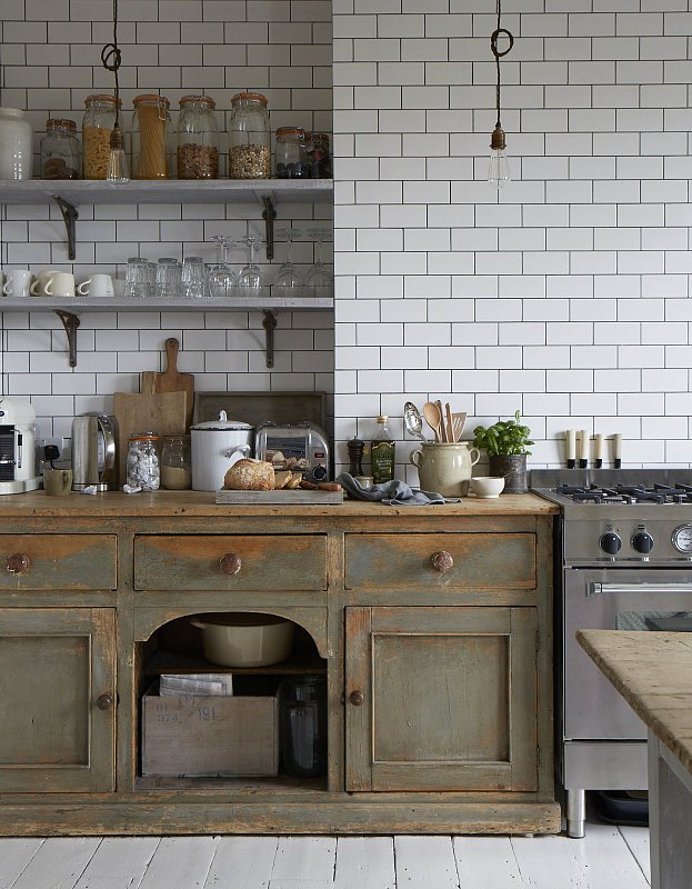 It seems the rustic green cabinetry is a stand-alone antique sideboard that a carpenter fit to size. It adds so much character and is a great example of how furniture can be used in place of traditional built-ins.