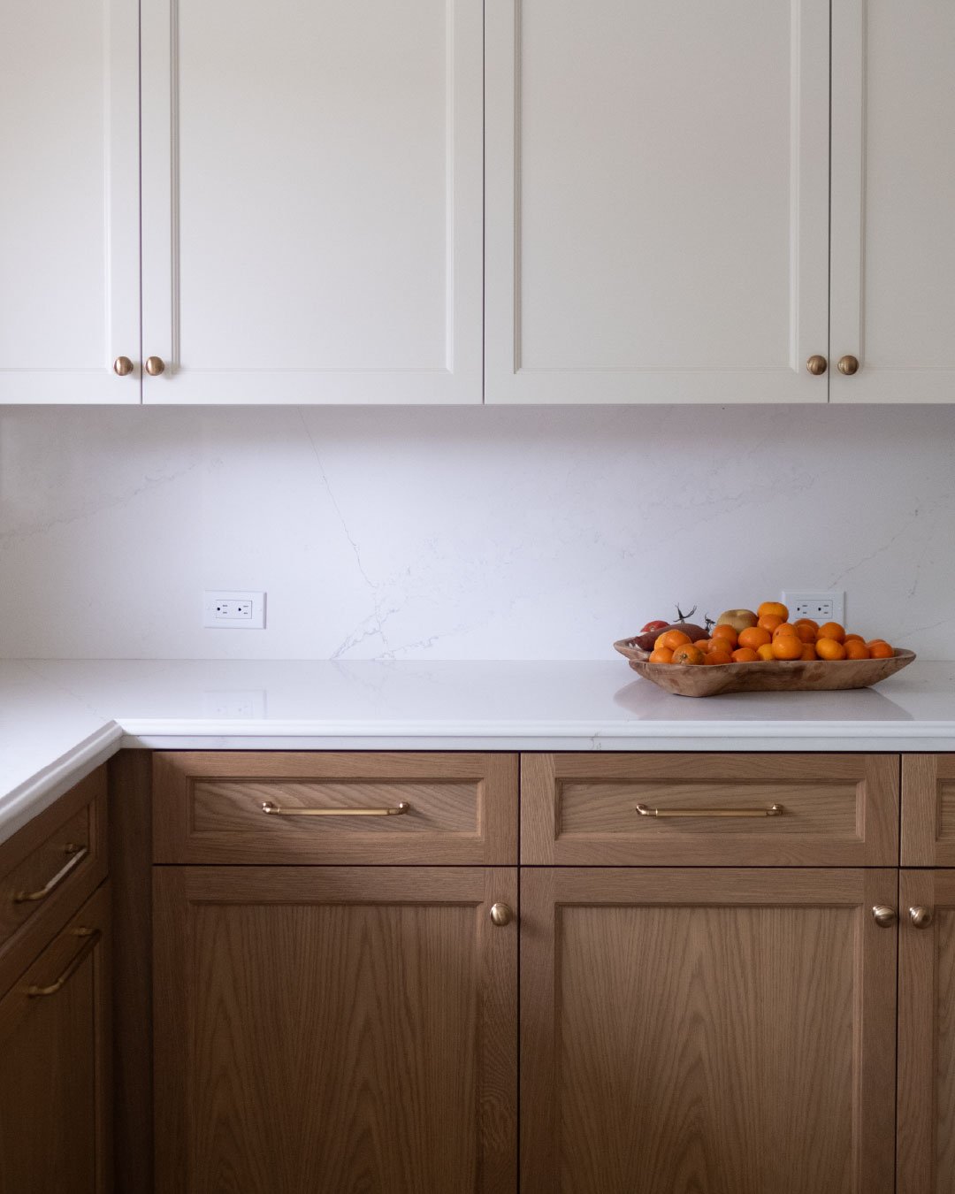 Natural light on a few expertly finished cabinets. Our in-house finishers used Sherwin Williams Dover White on the uppers. Rio (matte), a stain in Native Oak's core collection, was used for the base cabinets.