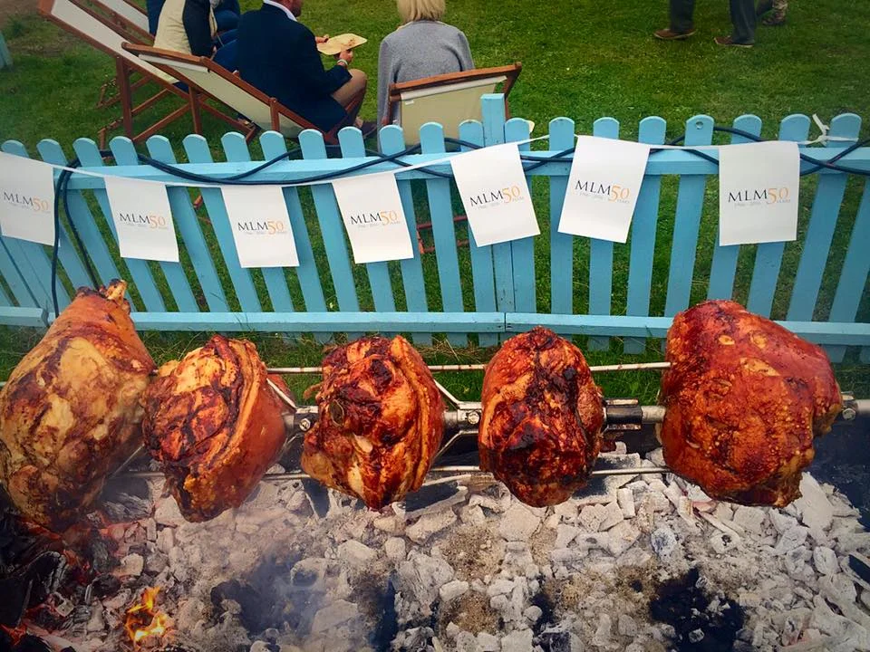 Pork legs cooking over hot coals