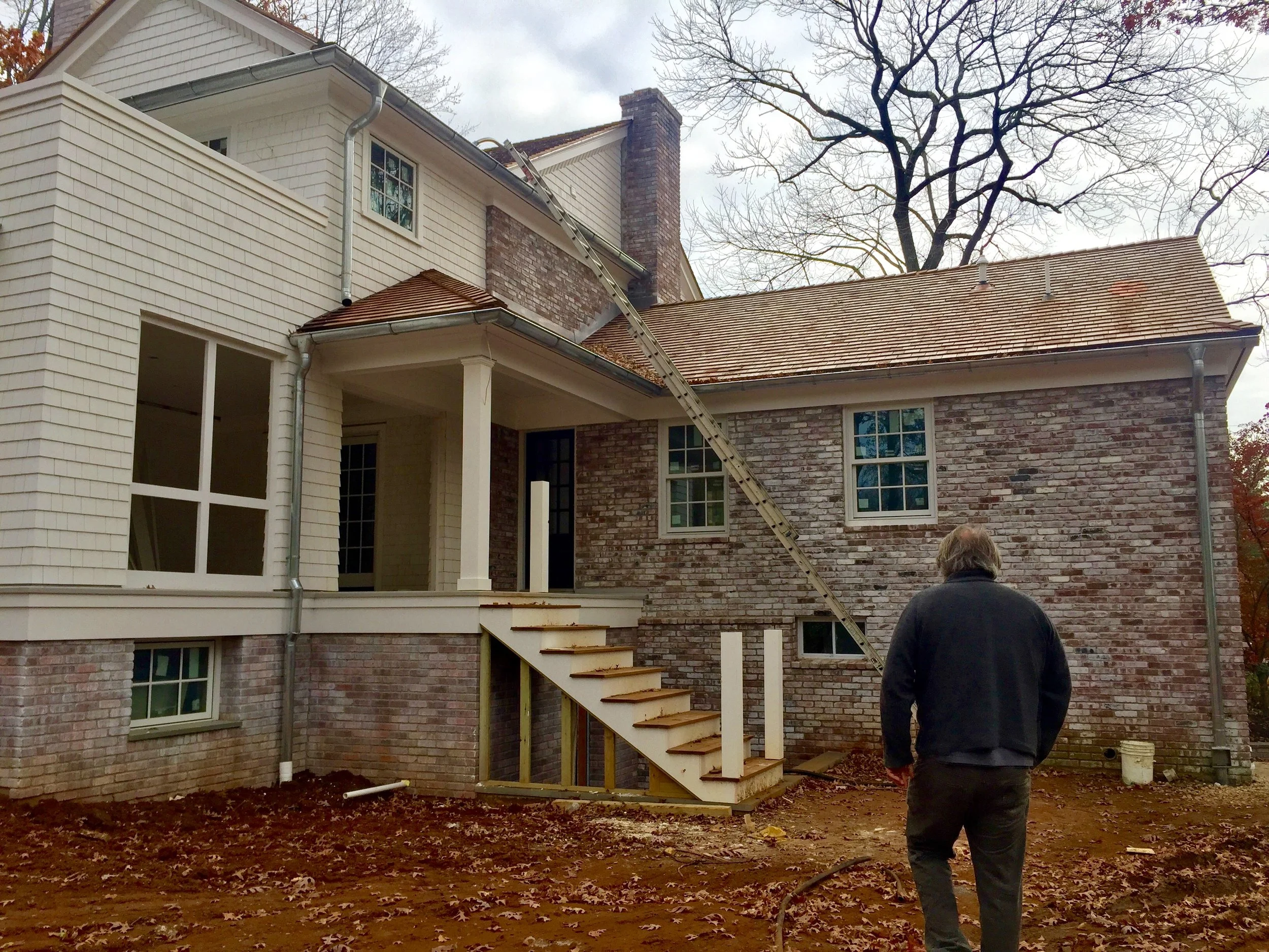 pickled brickwork, wooden tiled roof, galvanized steel gutter & wooden siding all match to original house & create a modern update to an elegant older home