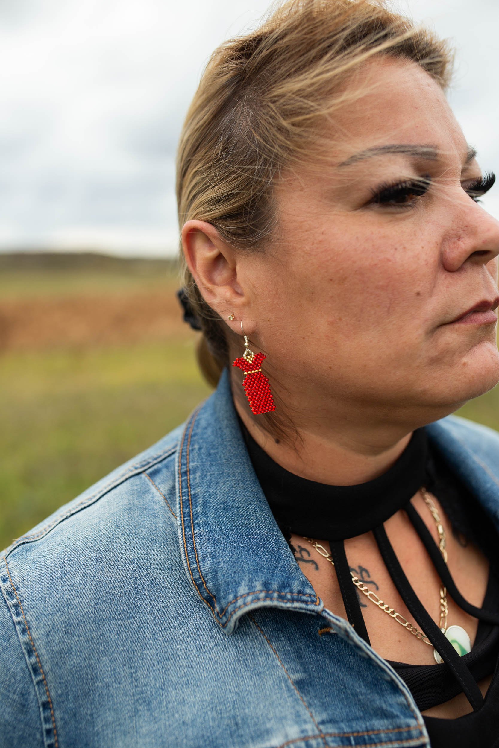  Melissa Robinson, family member of Morgan Harris, wears a pair of earrings of beaded red dresses in solidarity with Missing and Murdered Indigenous Women, Girls and Two Spirits (MMIWG2S) at Camp Morgan outside Brady Landfill in Winnipeg, Canada. Rob