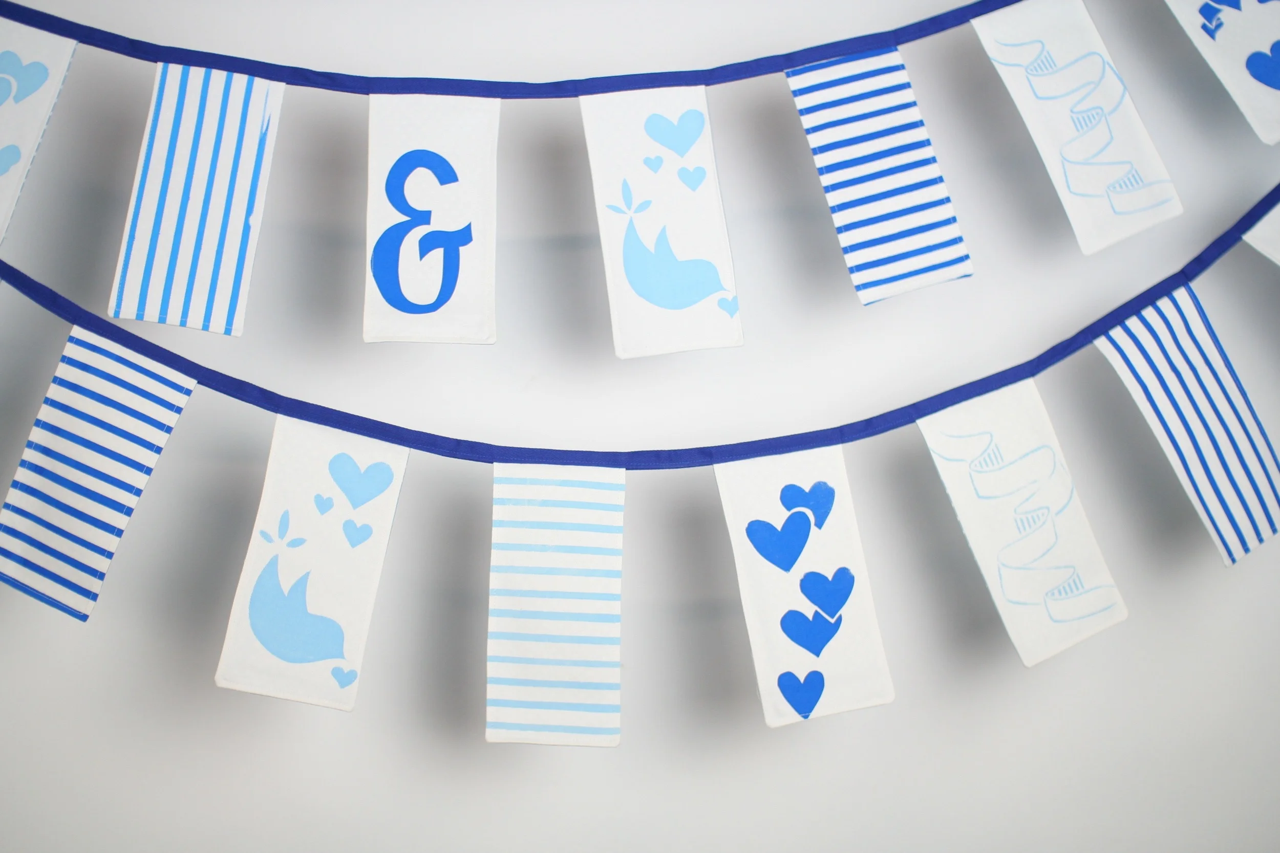 10.6 metres hand sewn and hand screen printed rectangular bunting: Flags measure 21 cm x 9 cm Flags are backed with pale blue polka dot cotton. HIRE: £3.5 per metre BUY: £12 per metre