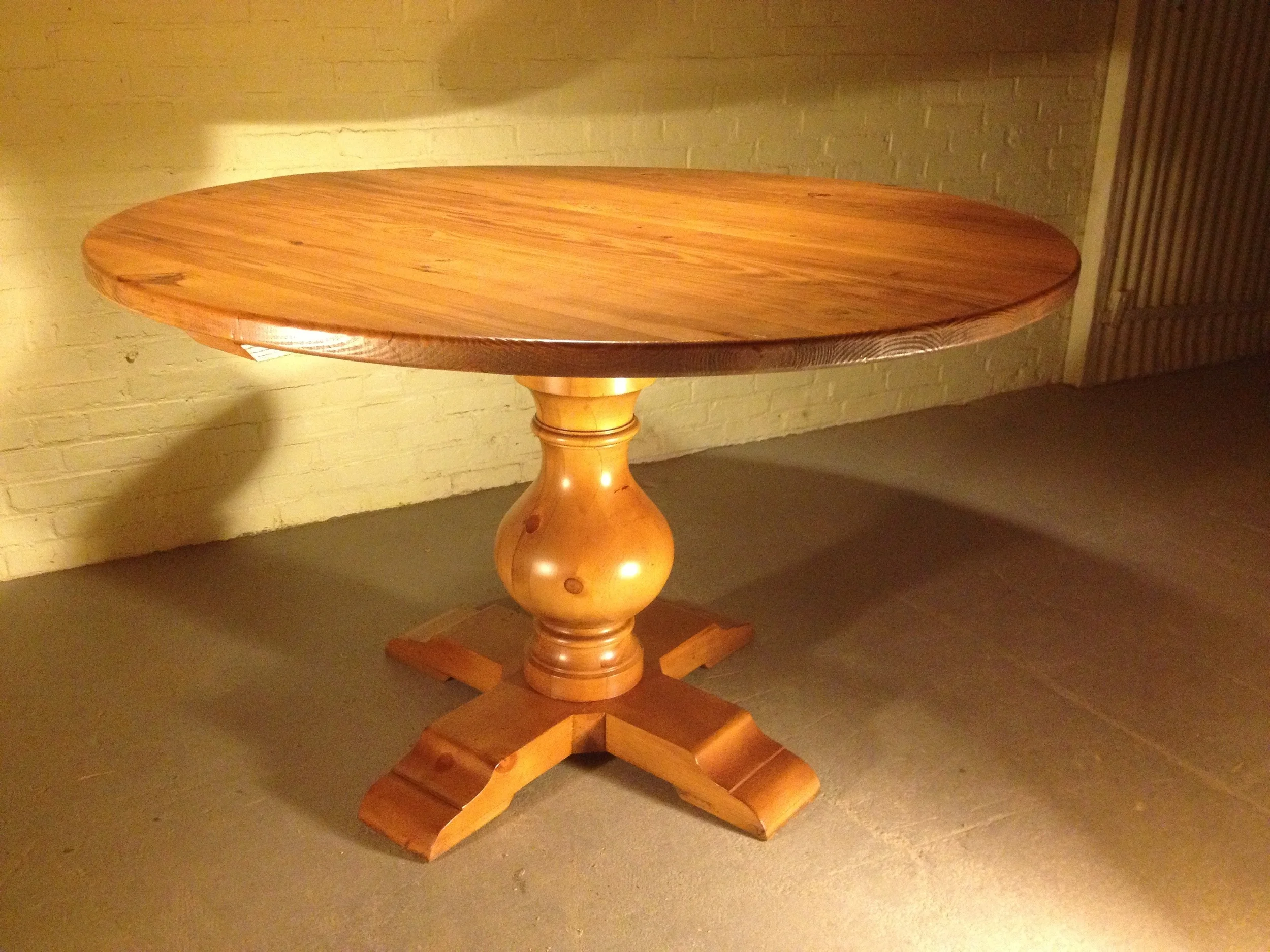 54" round thick top dining table with Grand Classic pedestal finished in Cinnamon