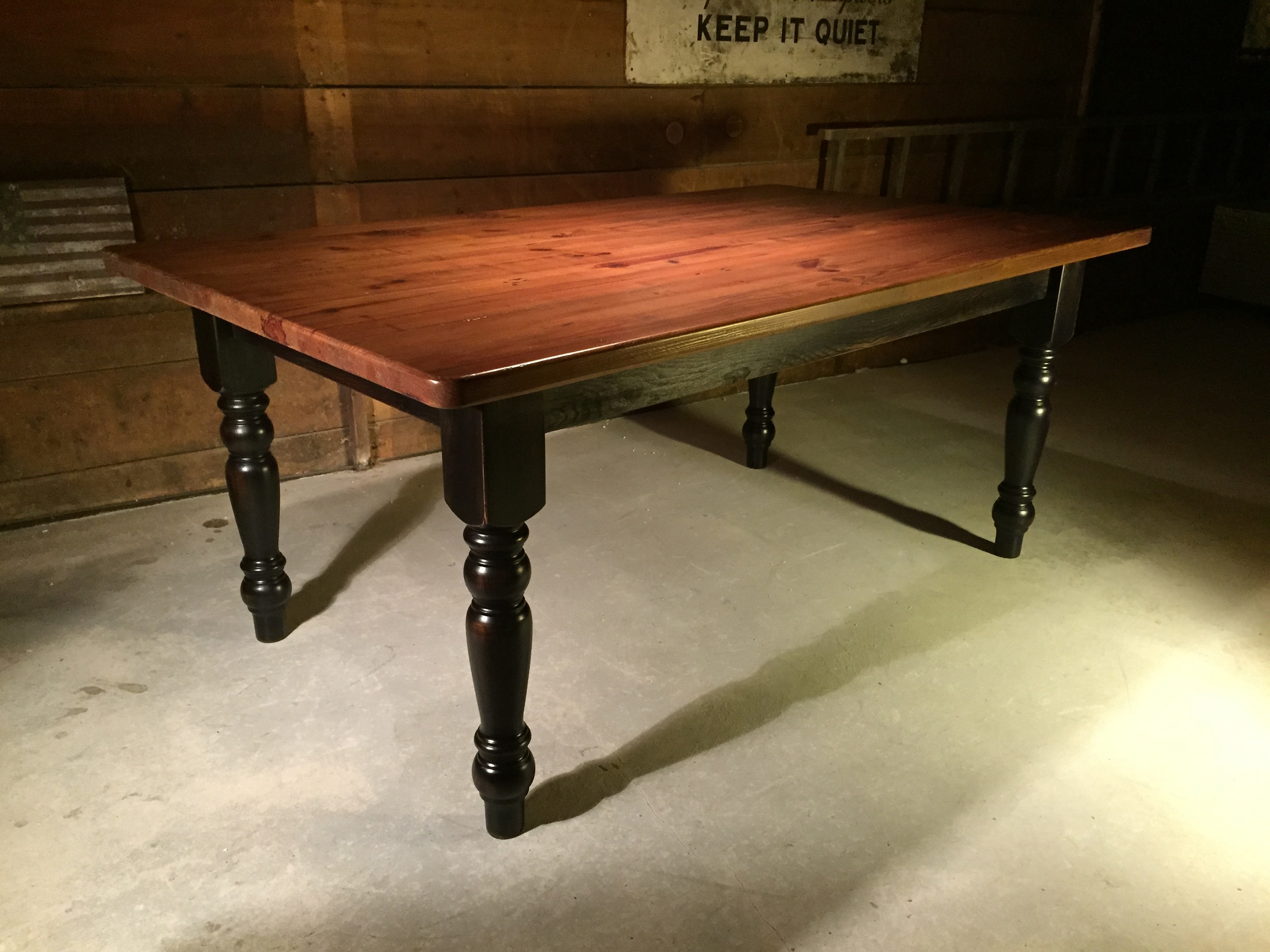 6' thick top dining table with American turned legs finished in a Hazelnut top and a Black distressed base