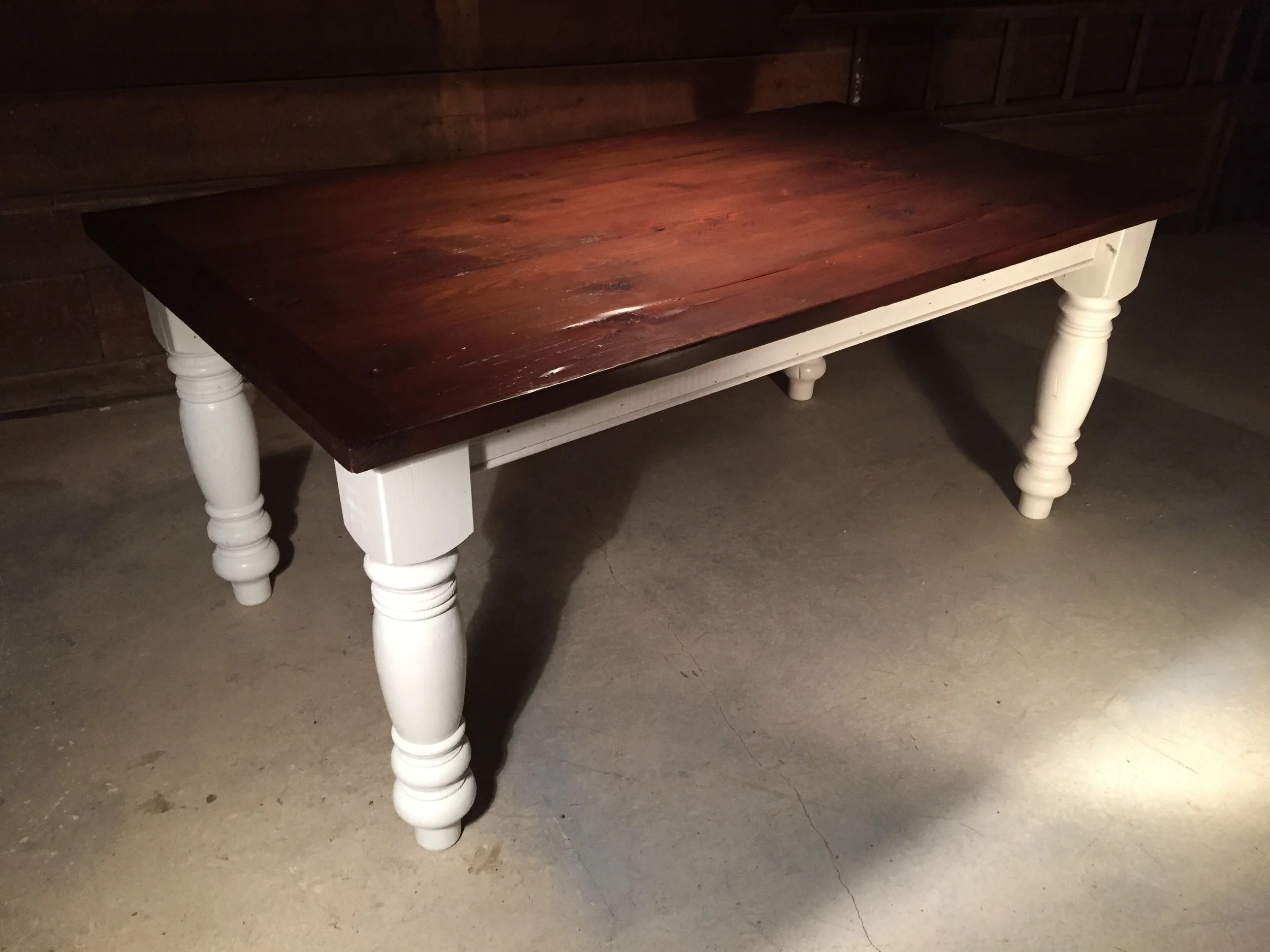 7' thick top English Pine dining table with 4" breadboards and oversized turned legs finished in Mahogany with a Snow White base