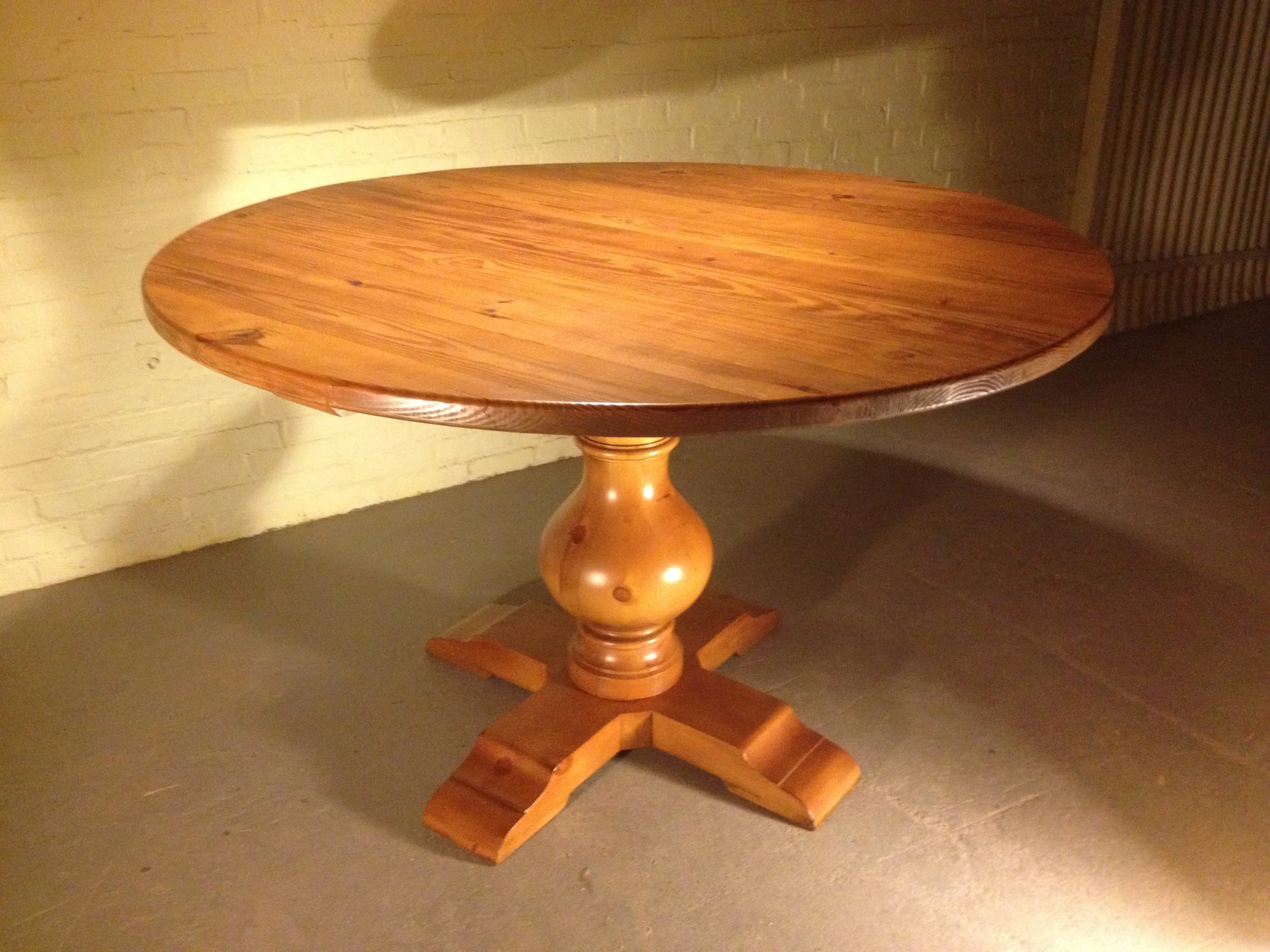 54" round thick top dining table with Grand Classic pedestal finished in Cinnamon