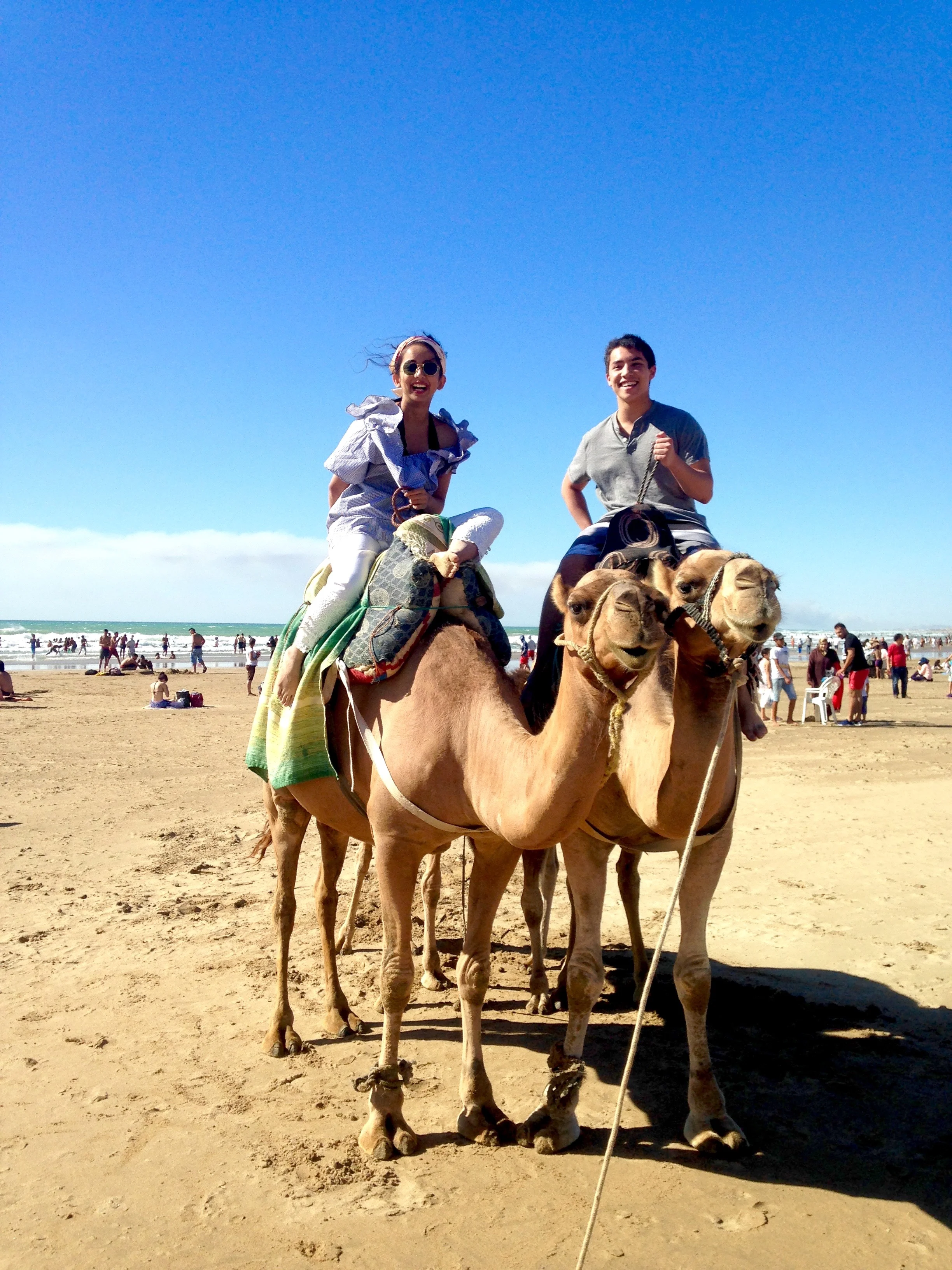 Students Hina Uddin and Alex Yung enjoy a camel ride on the beach.