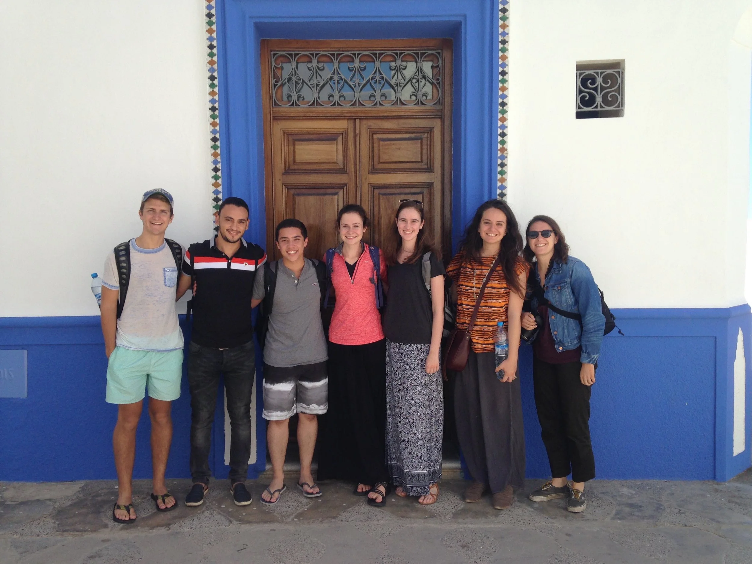 Students smile before one of the many beautiful doors in Asilah.