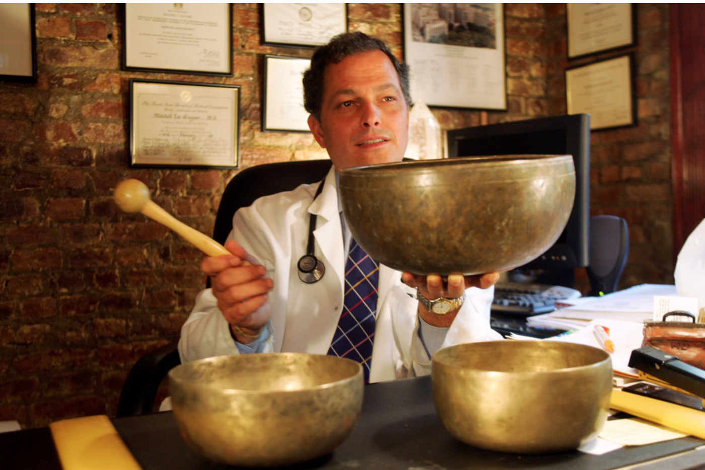 Dr. Mitchell Gaynor, with Tibetan singing bowls in a Manhattan office in 2005, advocated natural and traditional medicine. CreditJoyce Dopkeen/The New York Times