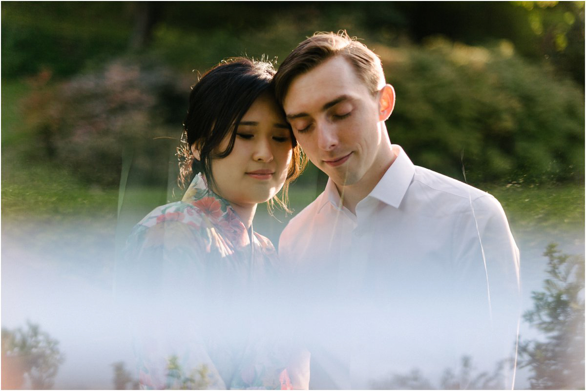  Asian Bride and British groom with their foreheads together with a reflection in a mirror 