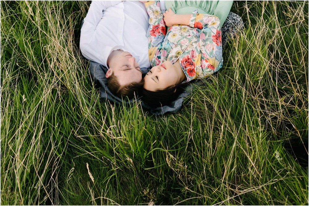  Korean girl and British boy sleep hugging in a tall grass in summer 