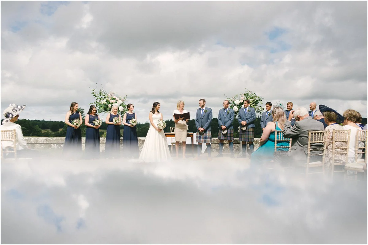 Summer Scottish castle wedding ceremony outdoors with a reflection in a pond in Blairquhan by Cro & Kow