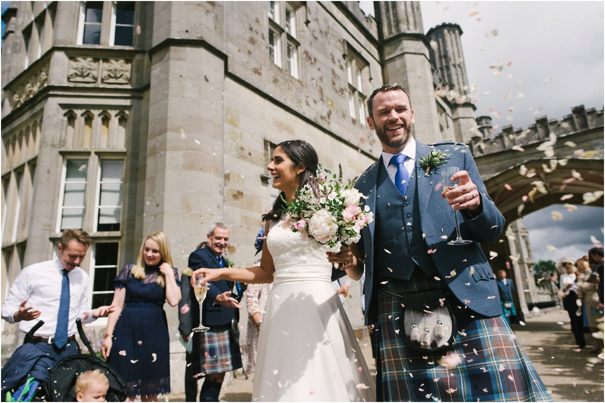  Newlyweds have confetti thrown over them by their guests at a Summer Scottish castle wedding in Blairquhan by Cro & Kow 