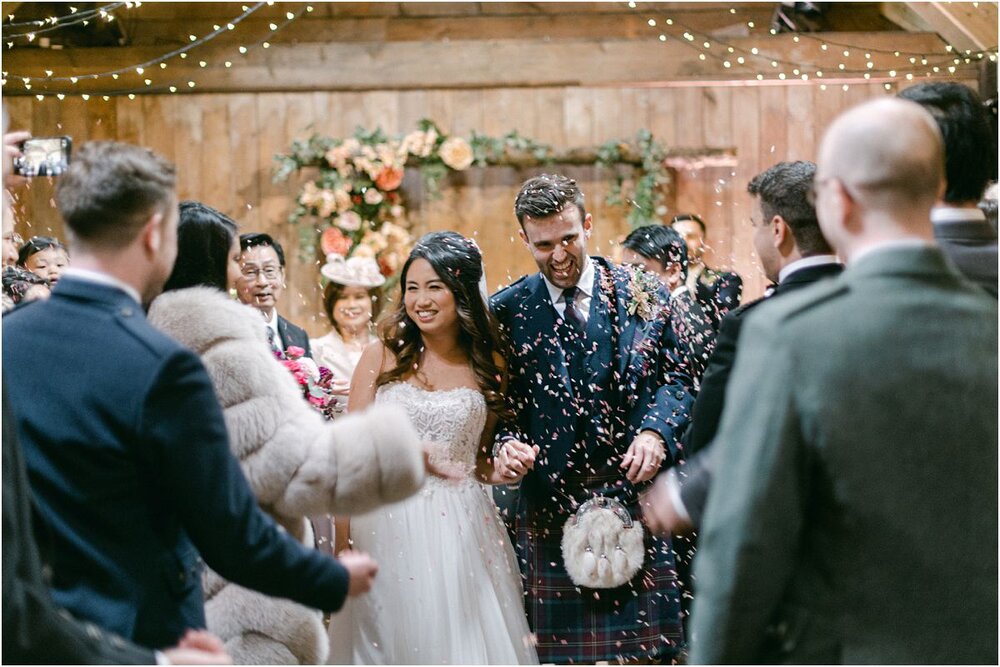  A couple leaving the ceremony in confetti at The Byre At Inchyra in Perthshire in Scotland by Crofts & Kowalczyk Photography 
