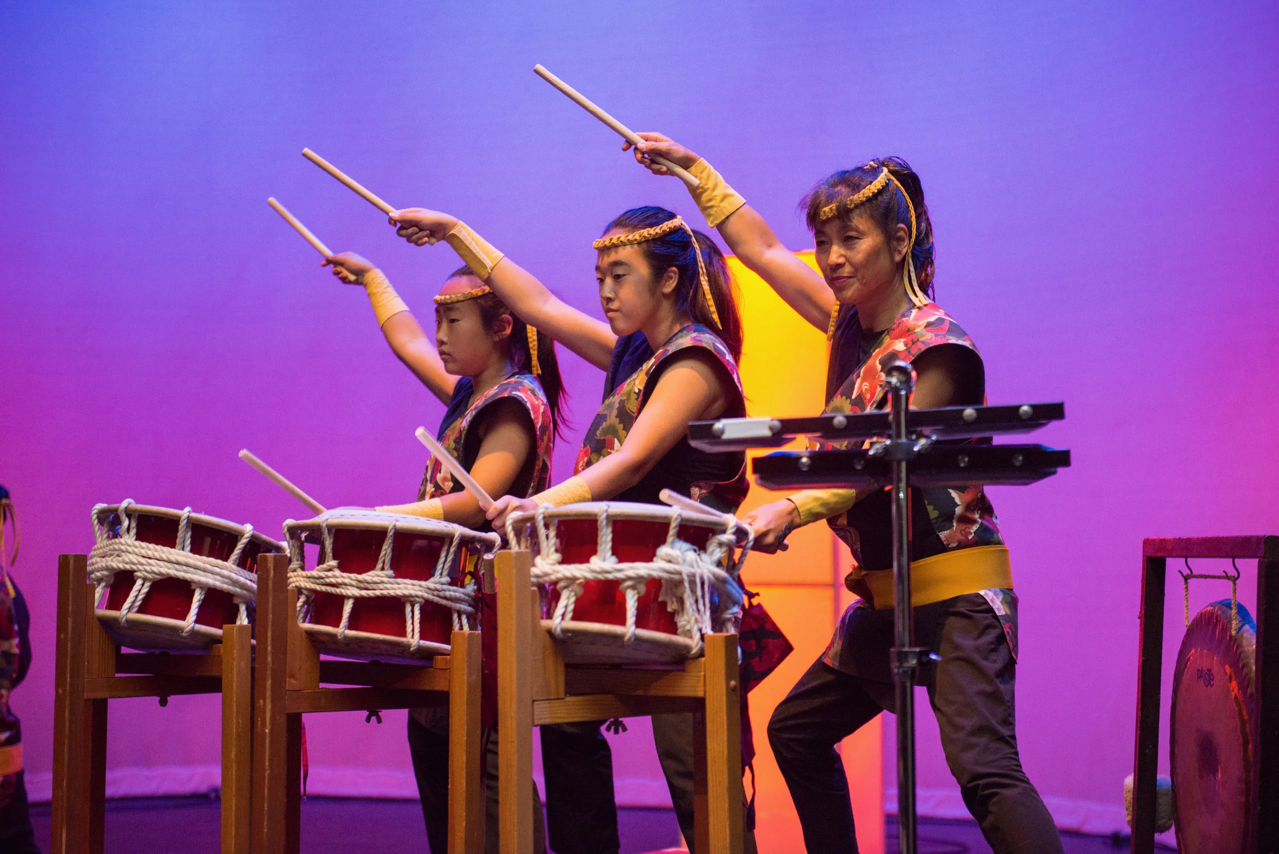 KOSHIN TAIKO Koshin Taiko traces its lineage back to the first professional taiko group in Japan. Oedo Sukeroku Taiko made history with its blend of classical Japanese music, martial arts, and dance, and its influence can be seen in taiko groups around the world. Sensei Etsuo Hongo brought the Oedo Sukeroku style to his own energetic compositions when he founded Koshin Taiko in 1992. In his unique form, powerful and beautiful taiko sounds are created through carefully choreographed movement. This synthesis of powerful sound and graceful movement, along with their visually distinctive Okedou, or rope‐tightened, drums, makes Koshin Taiko one of the most dynamic taiko groups in Los Angeles. Now under the leadership of Virginia Minami, Koshin continues to build upon this long tradition. By incorporating aspects of other styles of drumming while still exploring the rich traditions of Japanese taiko, Koshin continues to live up to the name Hongo Sensei gave it over twenty years ago: Bright Spirit.