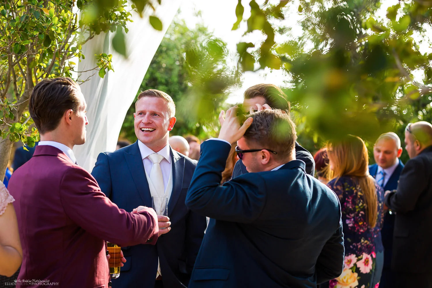 Groom enjoying mingling with his wedding guests. Photo by Elliot Nichol Photography.