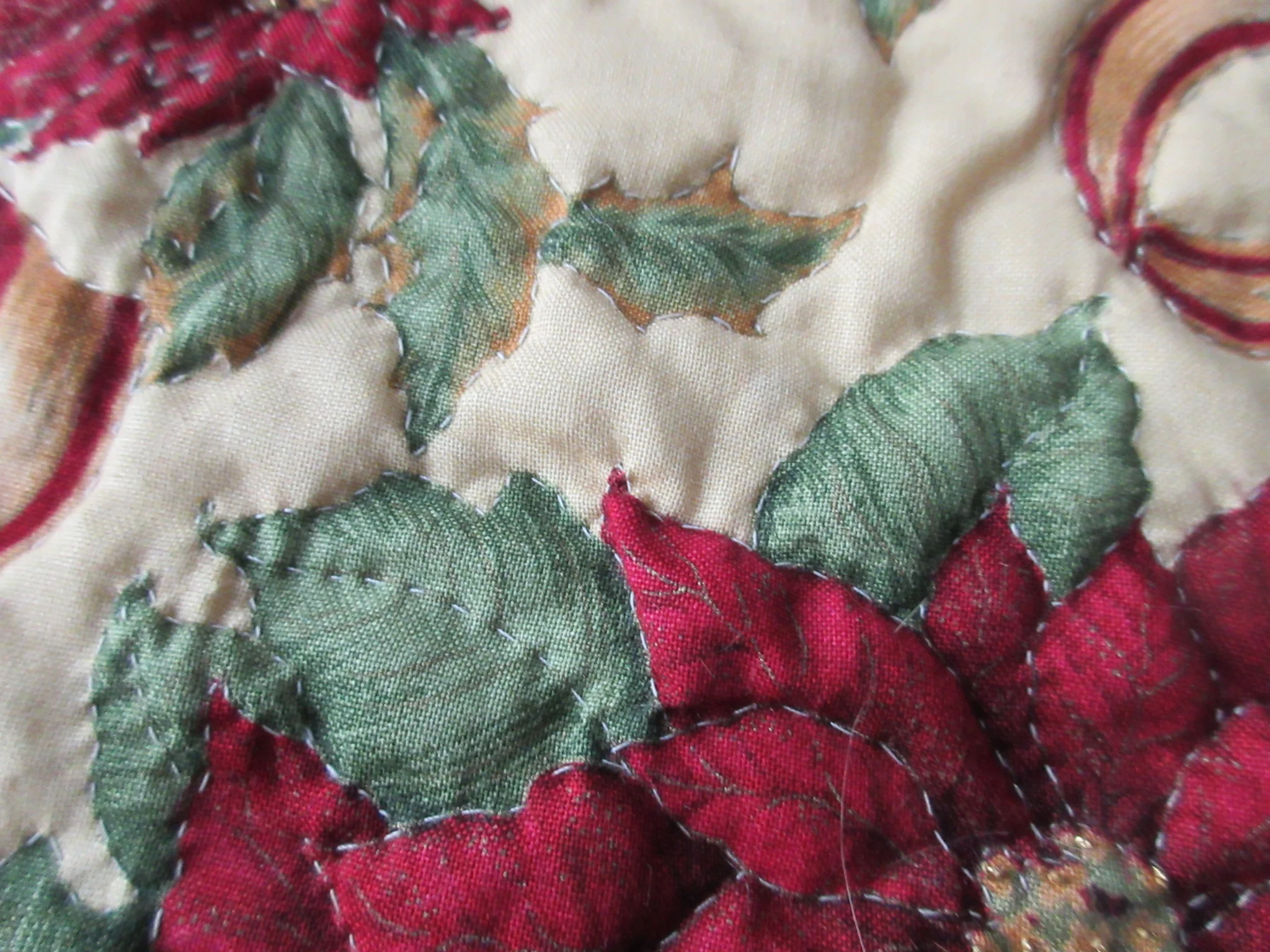 There are gold thread French knots in the centers of each flower (bottom right corner)