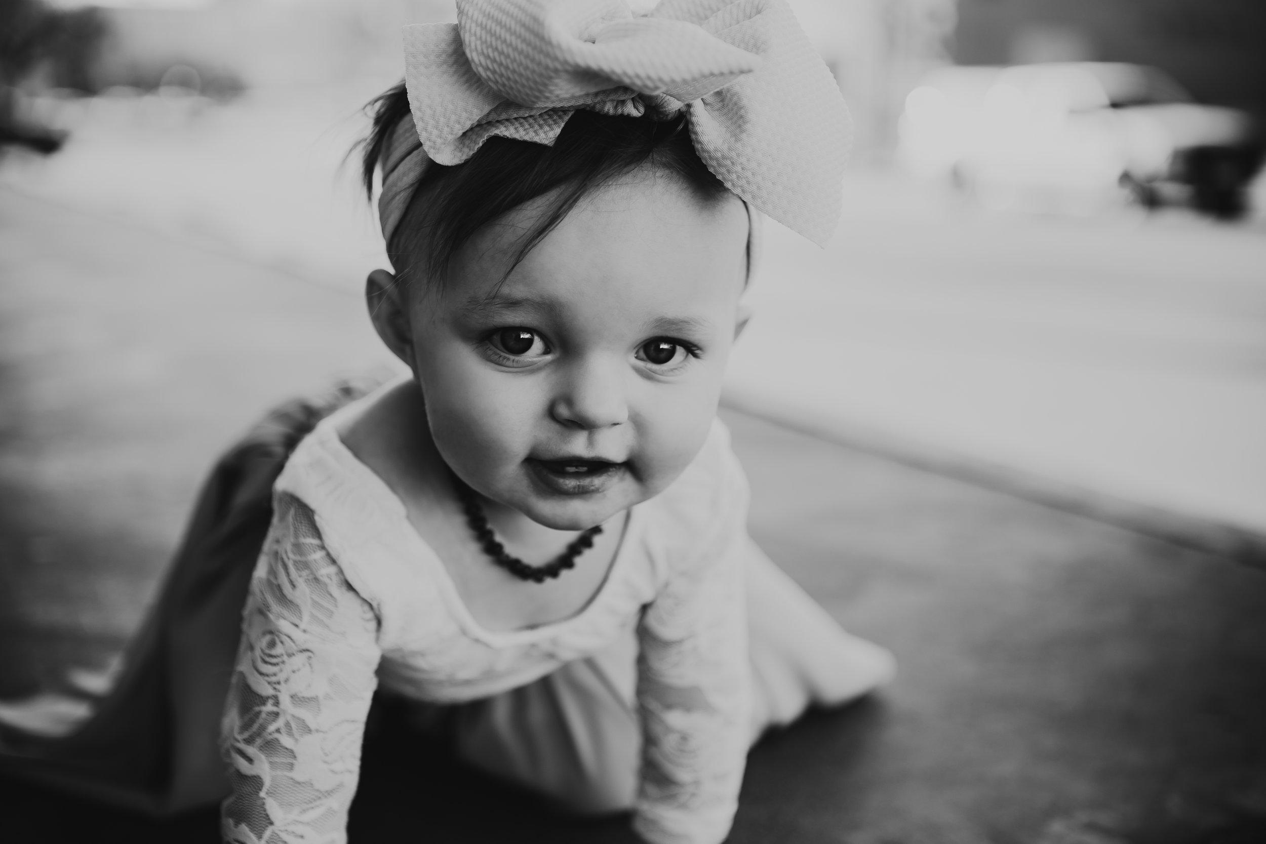 Black and white feature shot of little one crawling lace dress sleeves and large bow #rubyred #familyphotos #downtown #hairstyle #personality #amarillotexas #familyphotographer #lifestylephotos #amarillophotographer #locationchoice #texasfamilyphotos #familyofthree