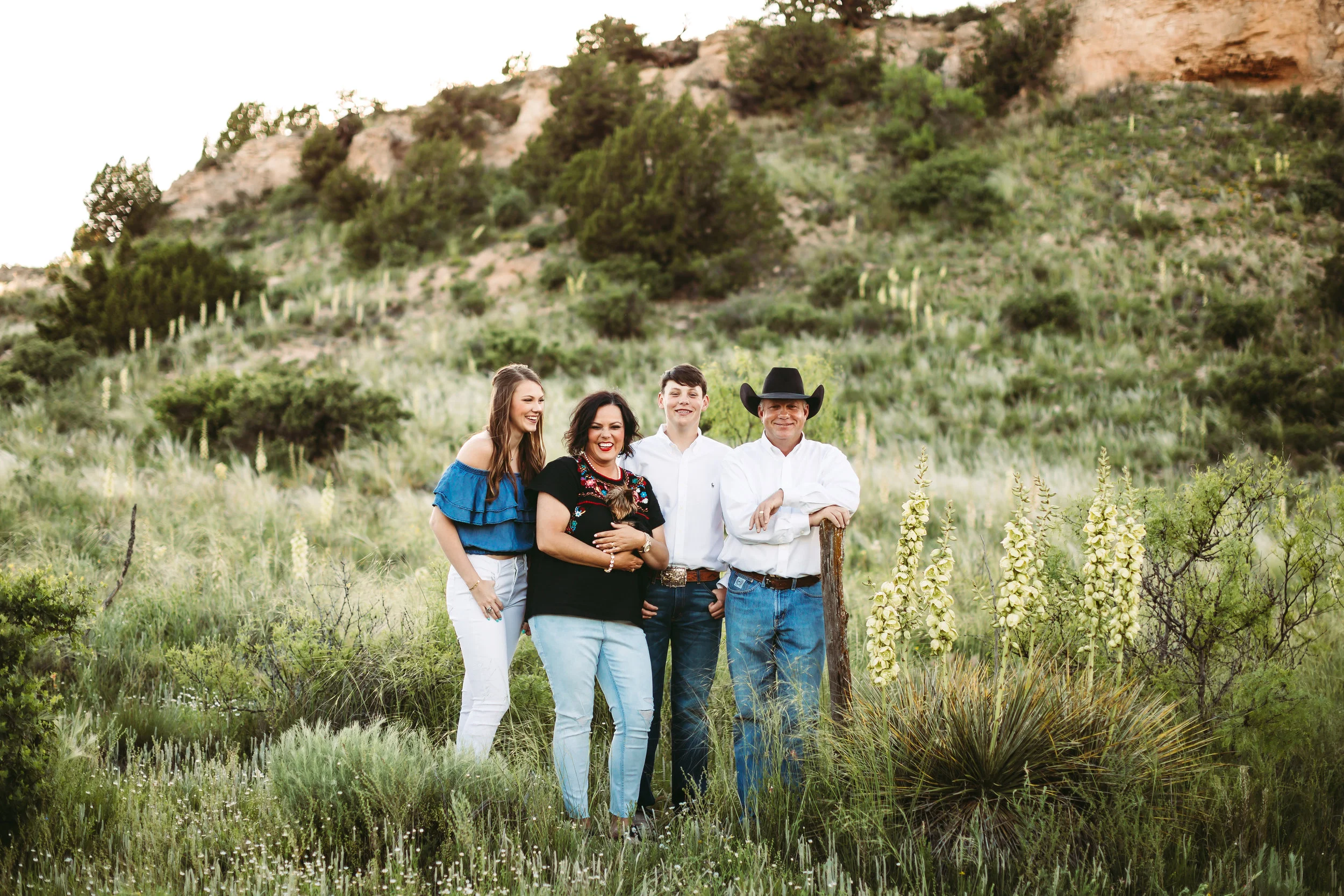 Family of four embracing on their family ranch #tealawardphotography #texasfamilyphotographer #amarillophotographer #amarillofamilyphotographer #lifestylephotography #emotionalphotography #familyphotosoot #family #lovingsiblings #purejoy #familyphotos #familyphotographer #greatoutdoors