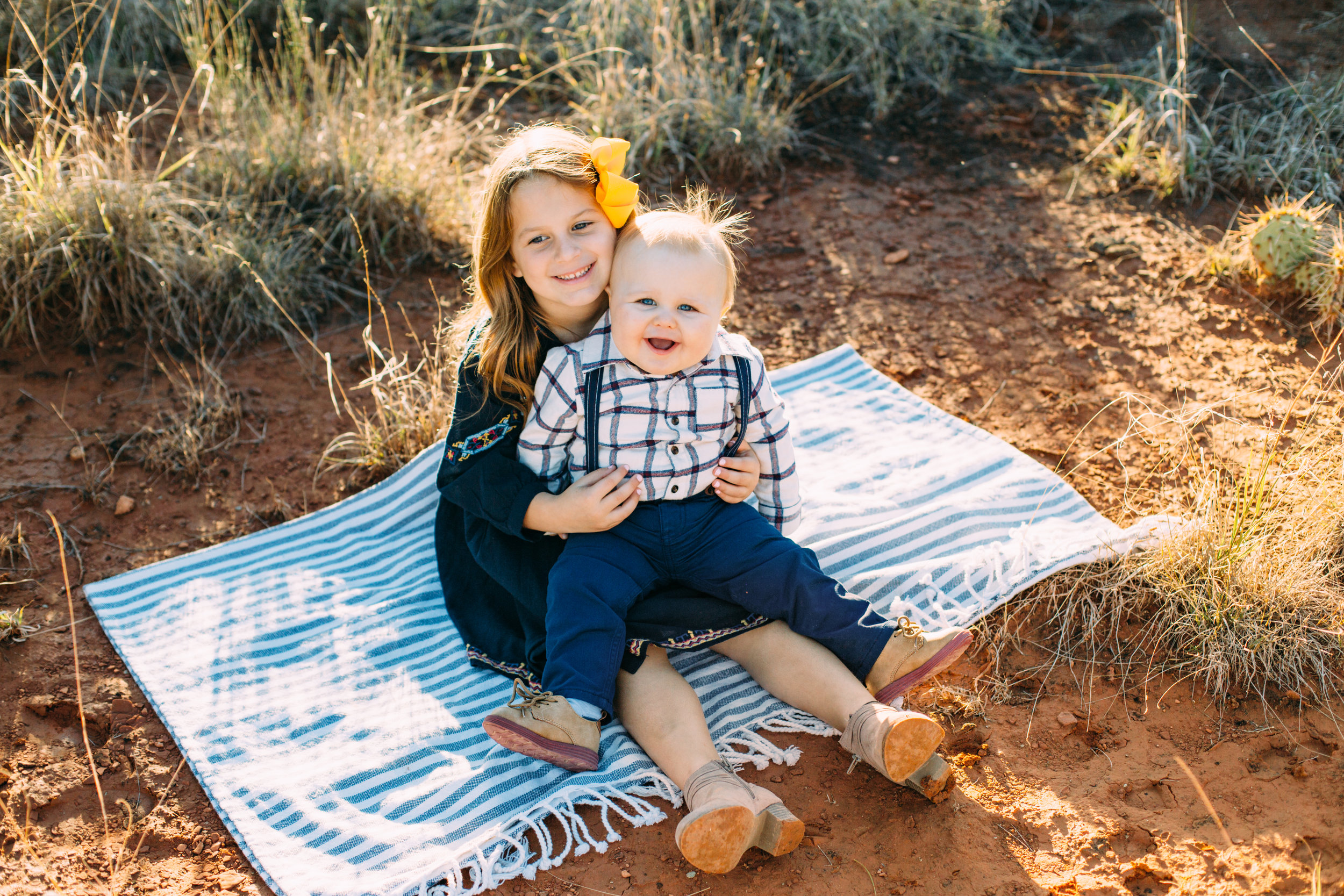 Brother and sister sit on picnic blanket while sister holds brother #tealawardphotography #texasfamilyphotographer #amarillophotographer #amarillofamilyphotographer #lifestylephotography #emotionalphotography #familyphotosoot #family #lovingsiblings #purejoy #familyphotos #familyphotographer #greatoutdoors
