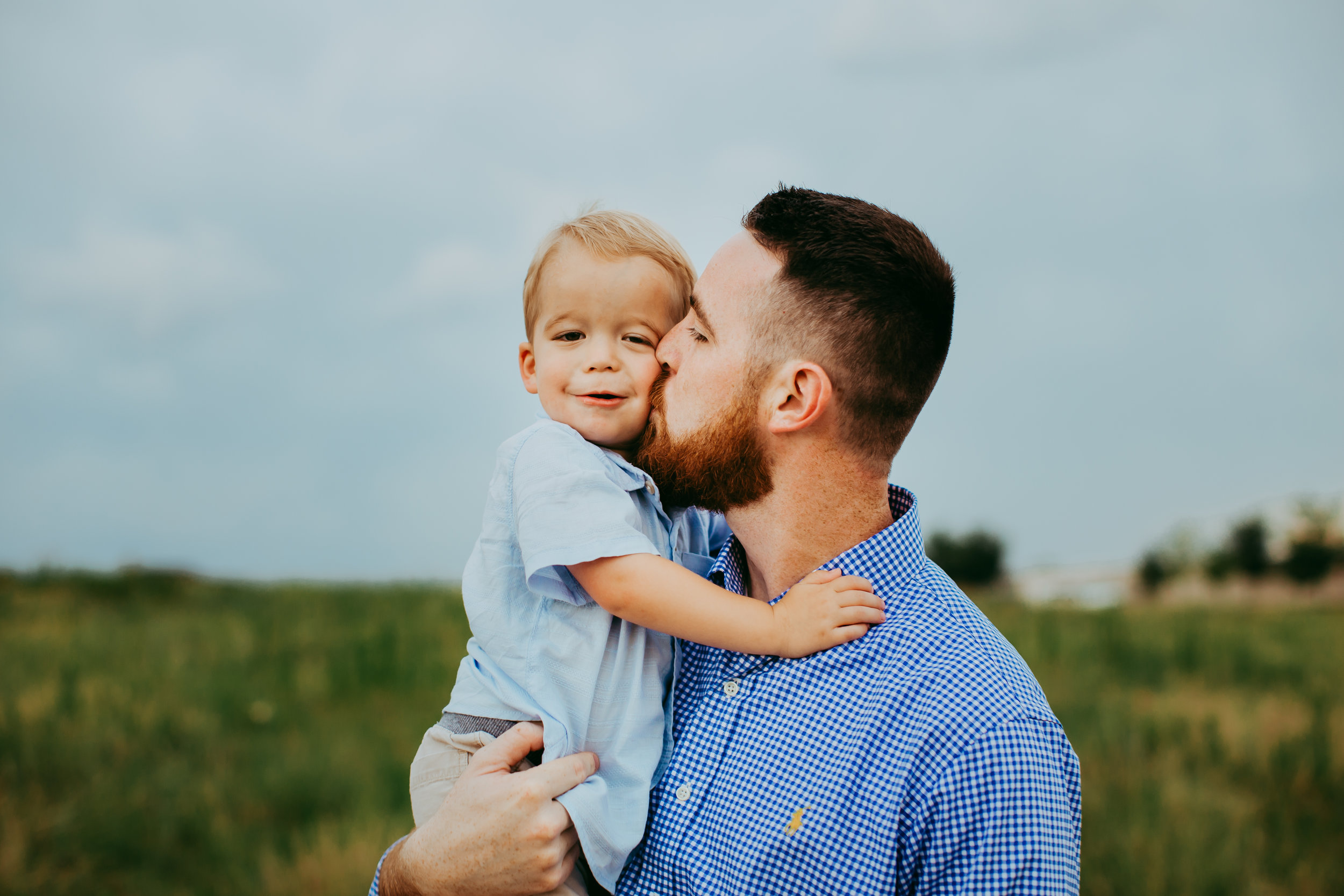  Dad kisses little one on the cheek both wearing different shades of blue #tealawardphotography #texasfamilyphotographer #amarillophotographer #amarillofamilyphotographer #lifestylephotography #emotionalphotography #familyphotosoot #family #lovingsiblings #purejoy #familyphotos #familyphotographer #greatoutdoors #naturalfamilyinteraction 
